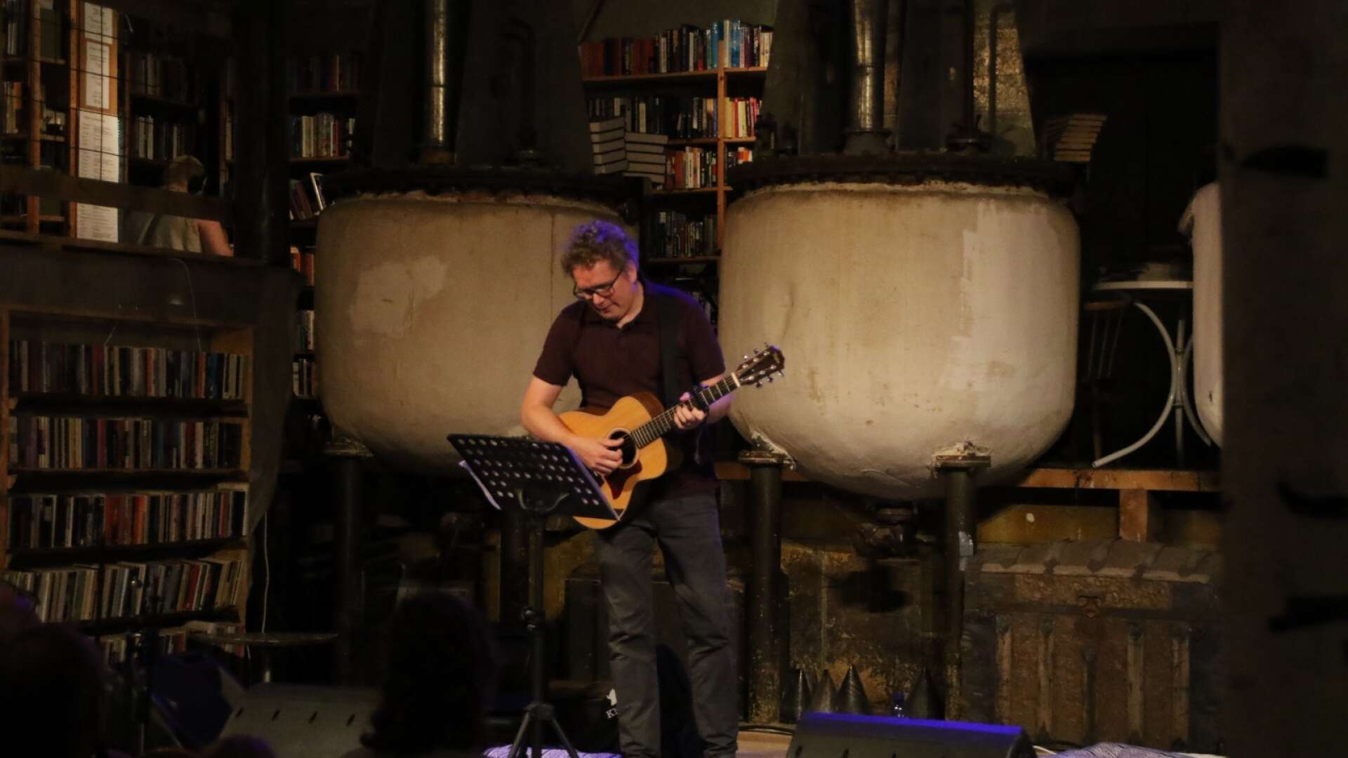 En artist som spelar på en liten scen innanför bokloppisen.