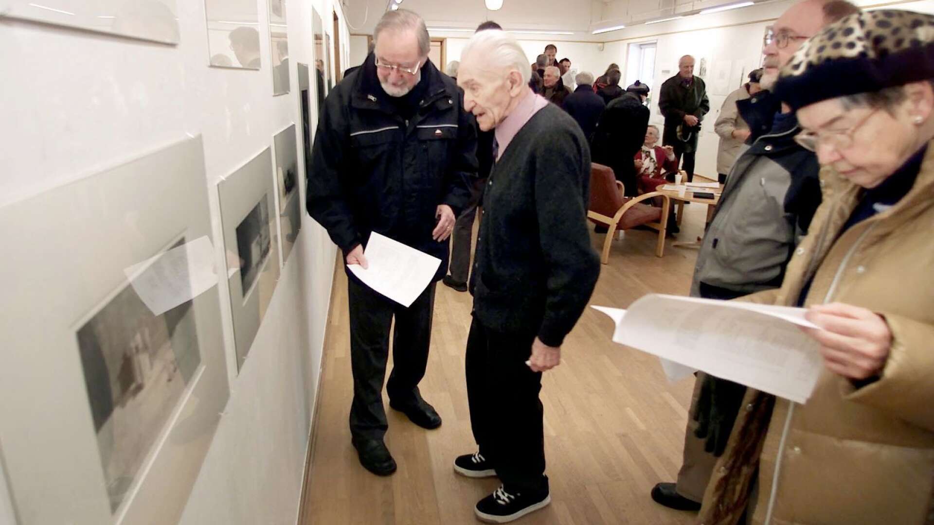Arkivbild. Konstnärskollegan John Waller, till vänster, och Einar Persson själv diskuterar några av bilderna i utställningen i januari 2004.