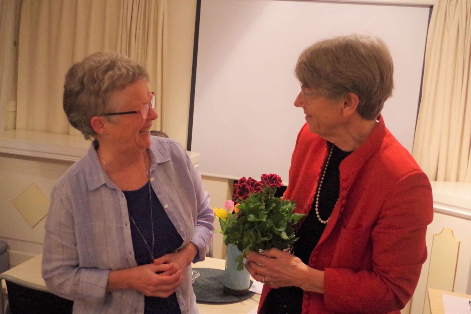 Maud Magnusson, till vänster, avtackades för tio års styrelsearbete med en blomma från ordförande Elisabet Rimeika.