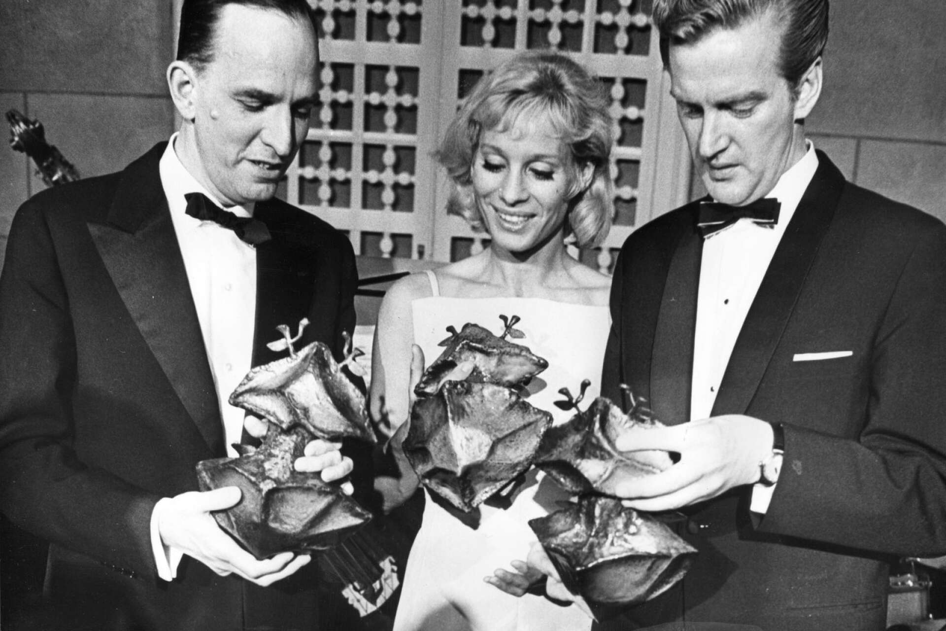 På Guldbaggen 1964 fick filmen Tystnaden tre priser: Bästa film, bästa regi och bästa kvinnliga huvudroll. Filmens regissör Ingmar Bergman syns här med Ingrid Thulin som spelade huvudrollen Ester, och Keve Hjelm som fick en Guldbagge för rollen Fadern i Kvarteret Korpen.