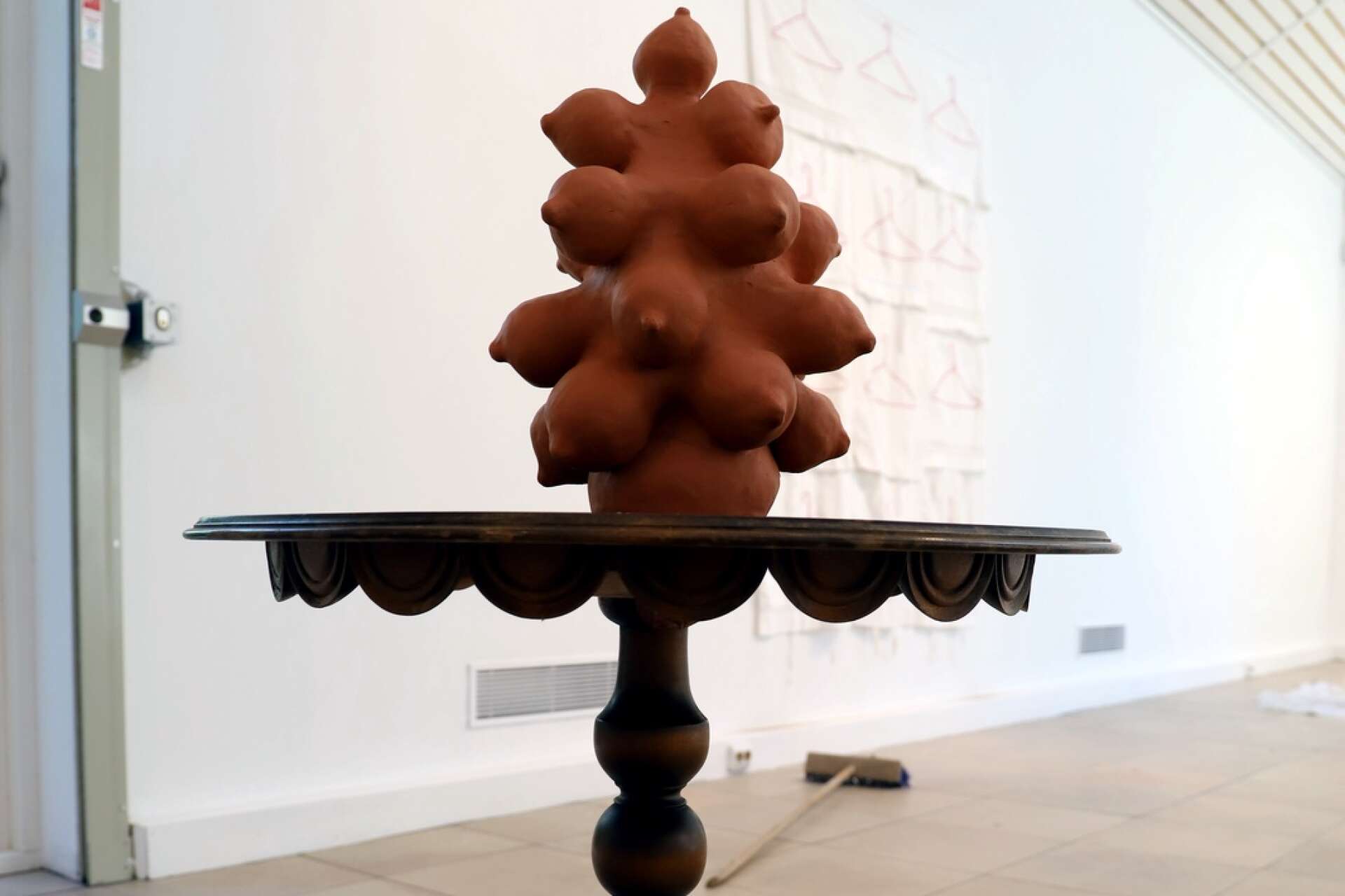 Skulpturen Trollmor har fått ett eget trollbord. Liv Midbøe arbetar med både keramik och textil, men trots kontrasterna som uppstår mellan dem, finns också många gemensamma teman i hennes båda linjer i konstnärskapet.
