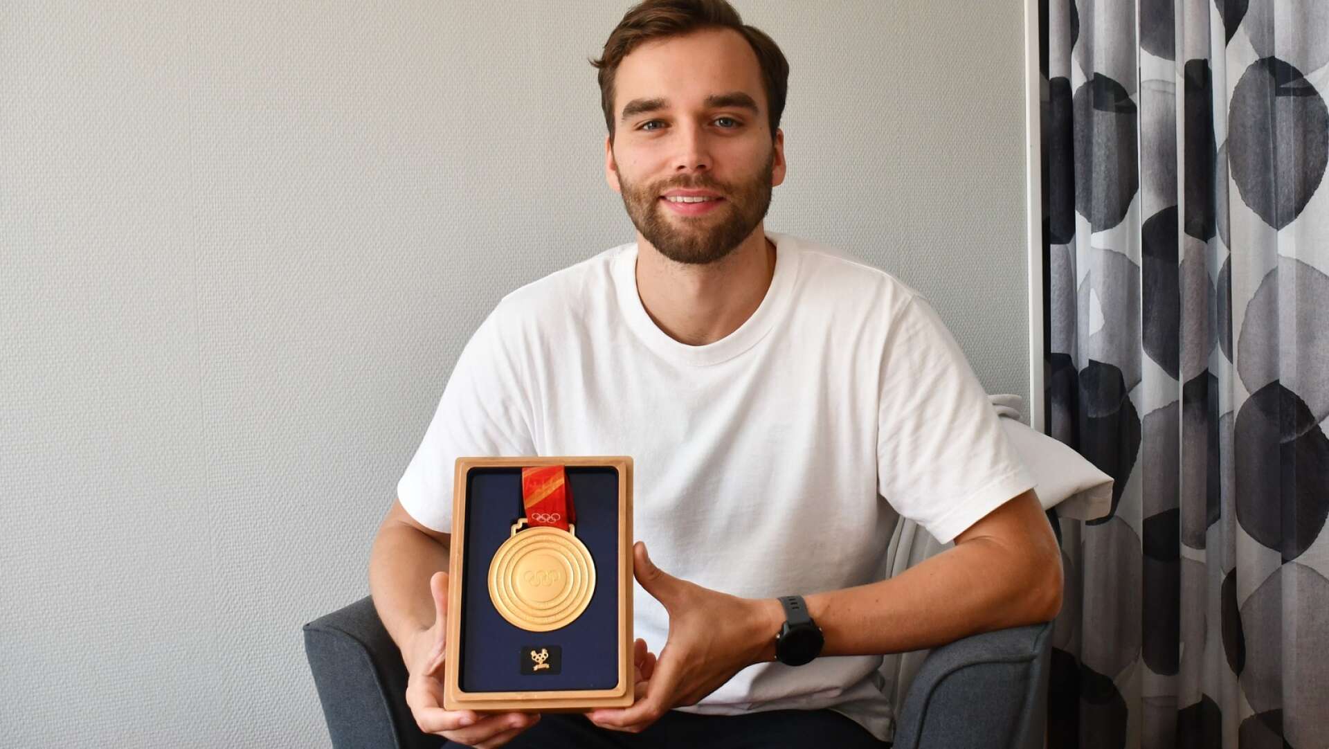 Oskar Eriksson visar upp beviset på det som är höjdpunkten hittills i hans curlingkarriär; guldmedaljen från OS i Peking.