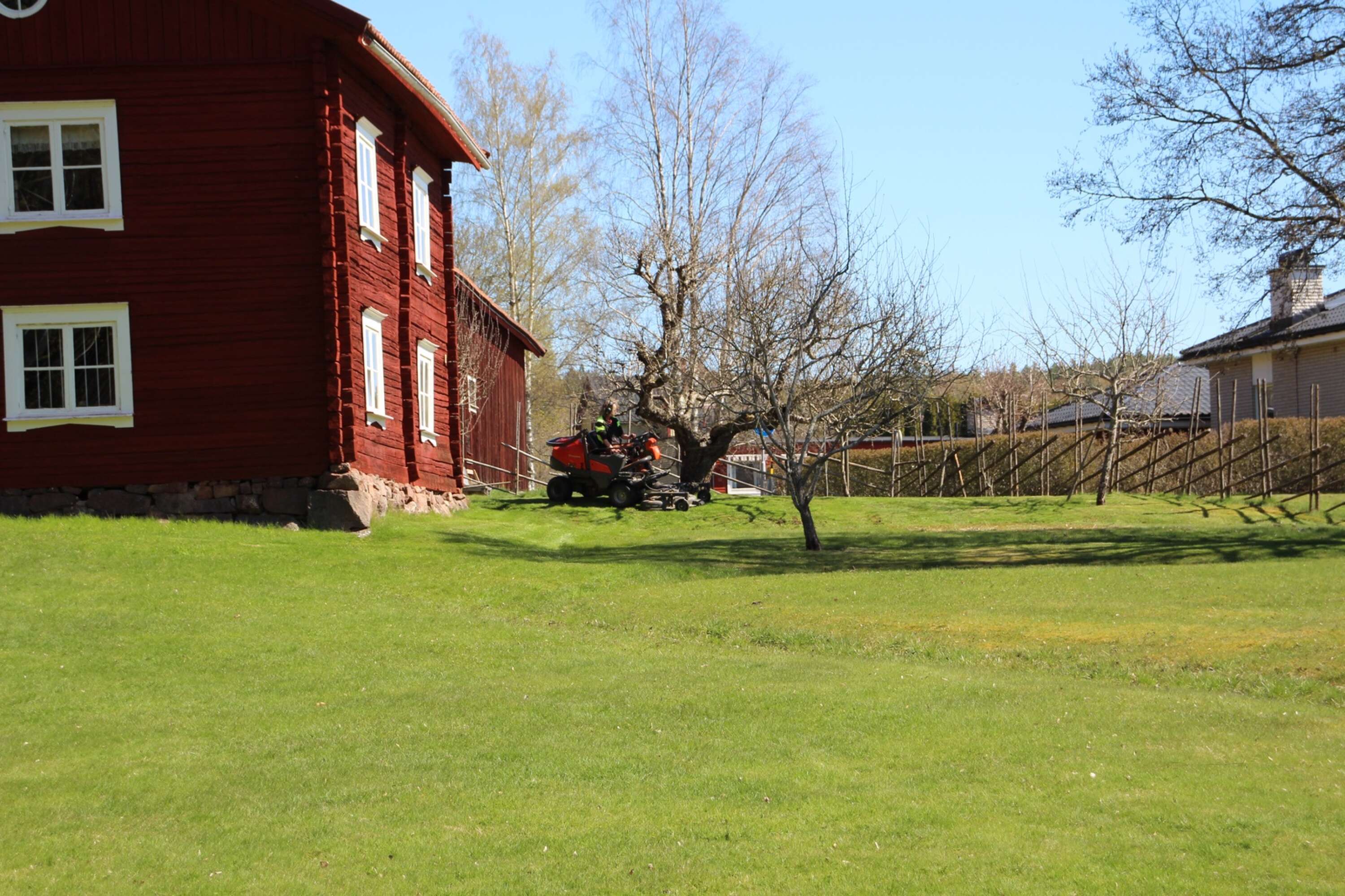 Vaktmästaren Björn klipper gräset vid Mjölnarbostaden, något som kommunen tidigare ansvarade för. 