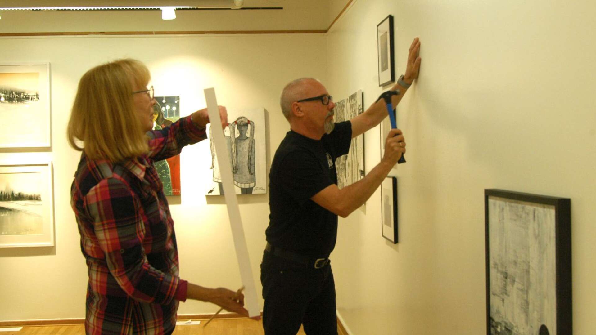 Nina Henriët och Tord Saxin vid hängningen av samlingsutställningen i konsthallen i Karlskoga.