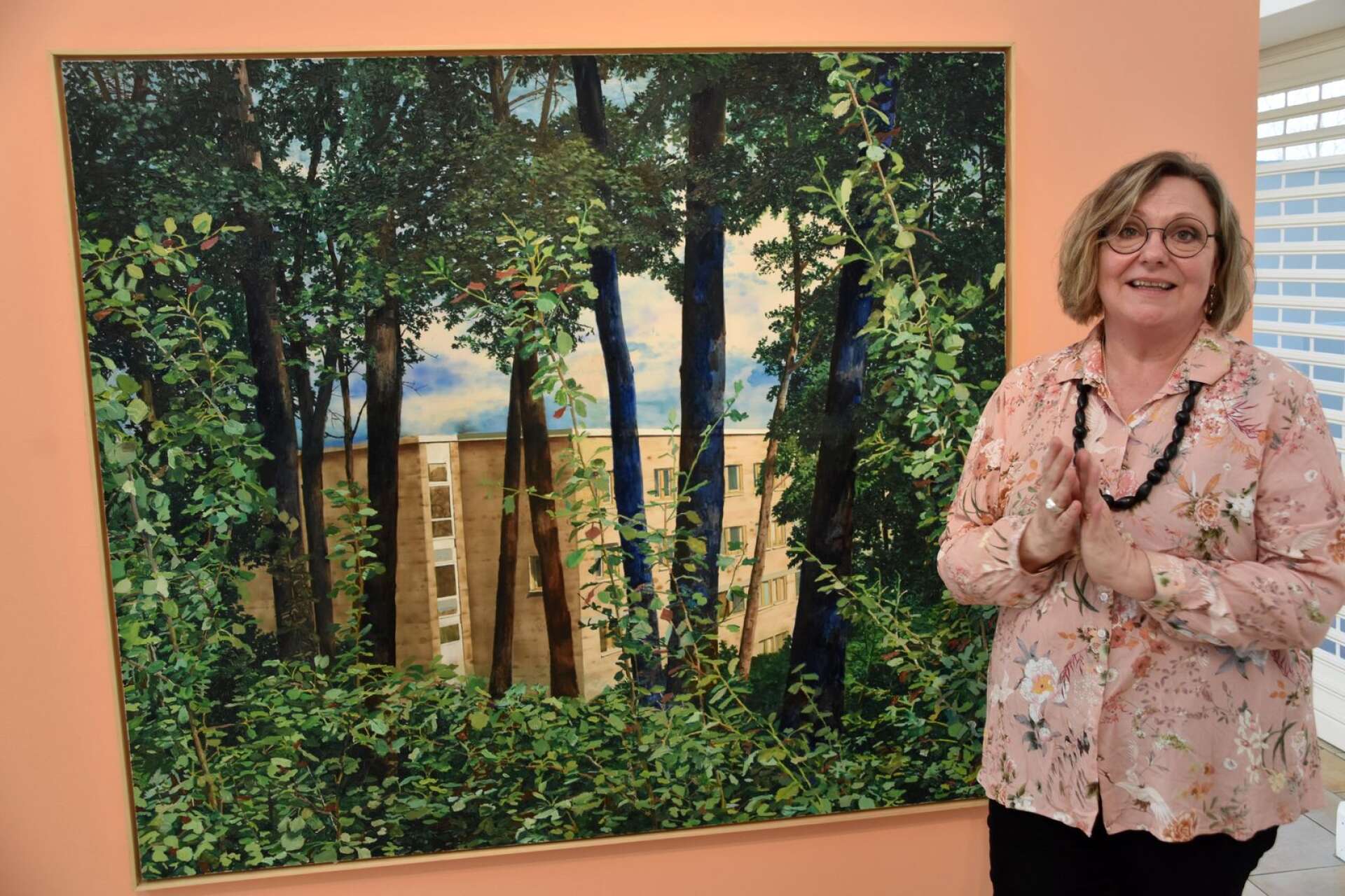 Museichefen Anneli Strömberg framför en av sina egna favoriter på utställningen på temat skog och stad. 
