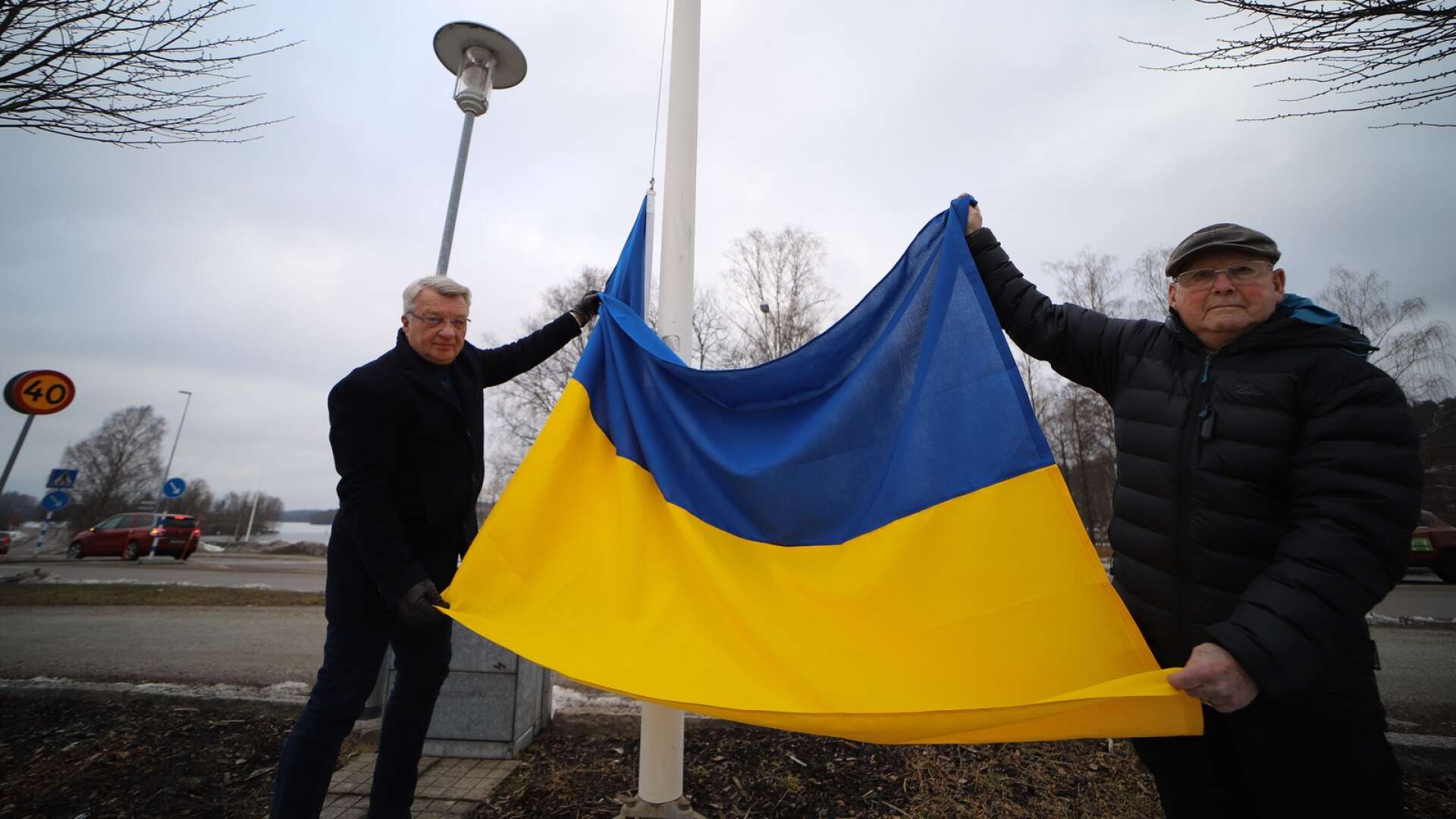 Stig Bertilsson (M), kommunstyrelsens ordförande, och Jan-Åke Jansson (KD), kommunfullmäktiges ordförande med flaggan från Ukraina som sedan en vecka vajar bredvid den svenska på Tingshustorget.