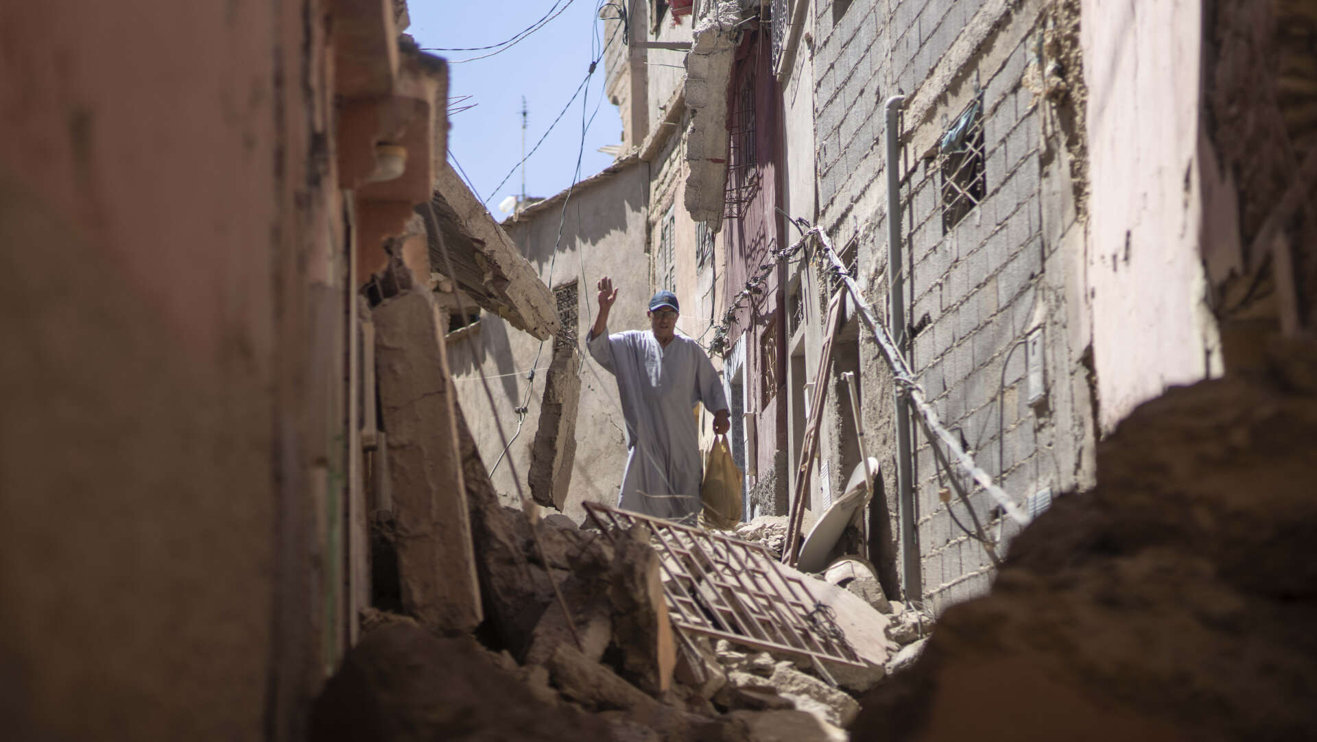 En man försöker ta sig fram bland raserade hus i byn Amizmiz nära Marrakech.