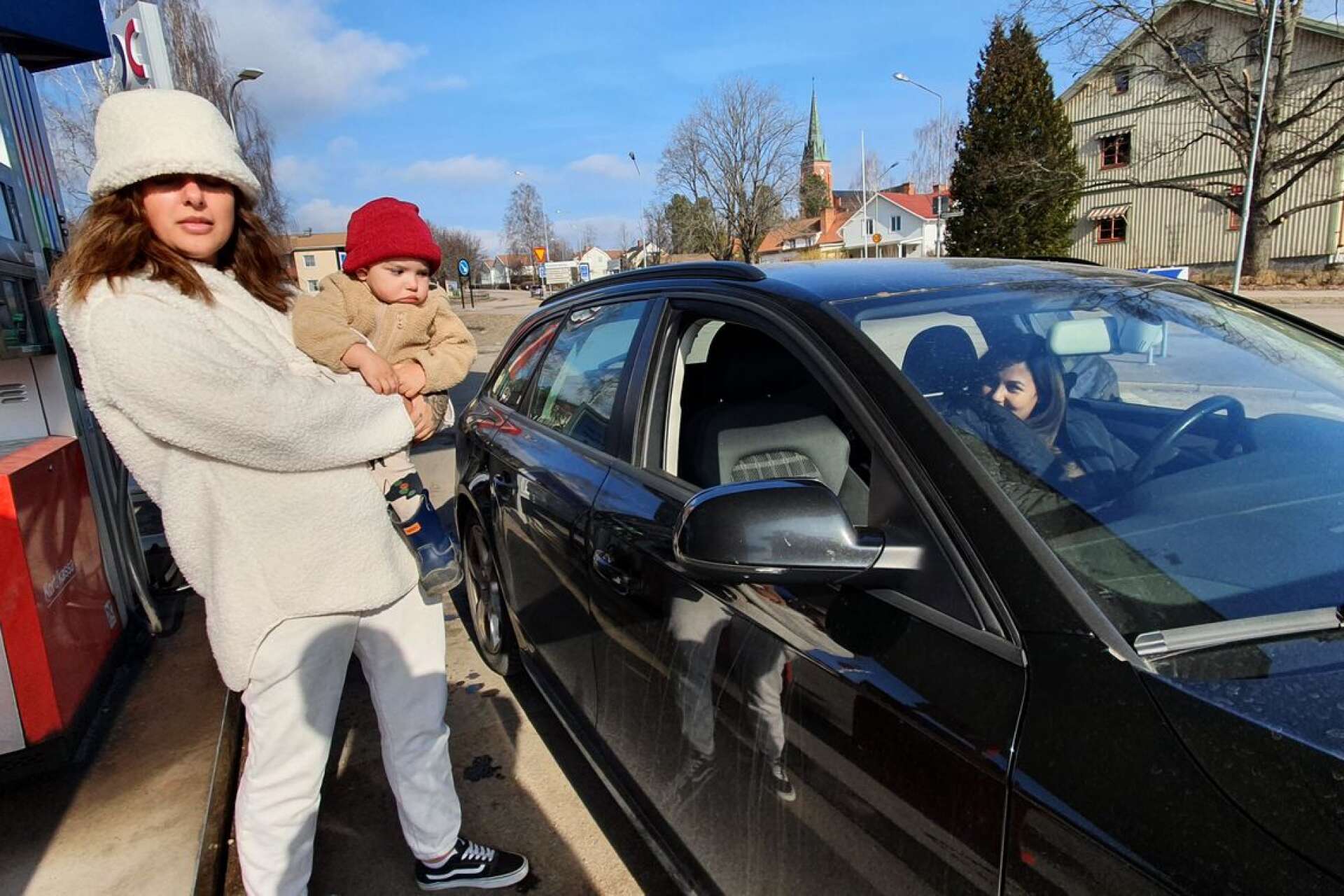 Lulsandra Asplund (i bilen) har tankat diesel i Torsby, medan hennes Elton, två år, tas hand av systern Iana.