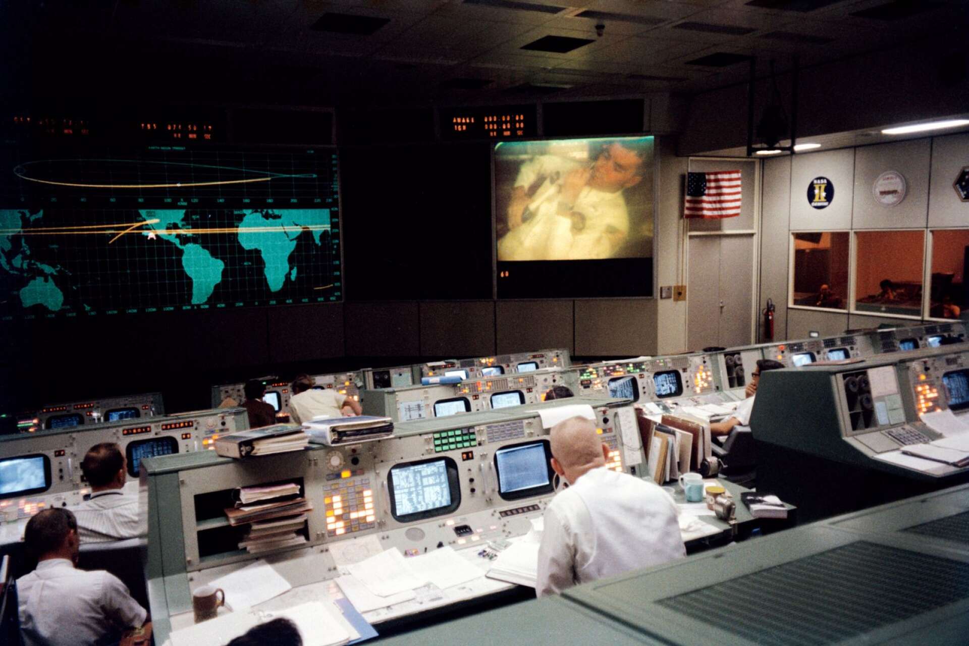 Markkontrollen (Mission Control) i Houston, Texas under Apollo 13. Astronauten Fred Haise på skärmen och flygledaren Gene Kranz med ryggen mot kameran.

