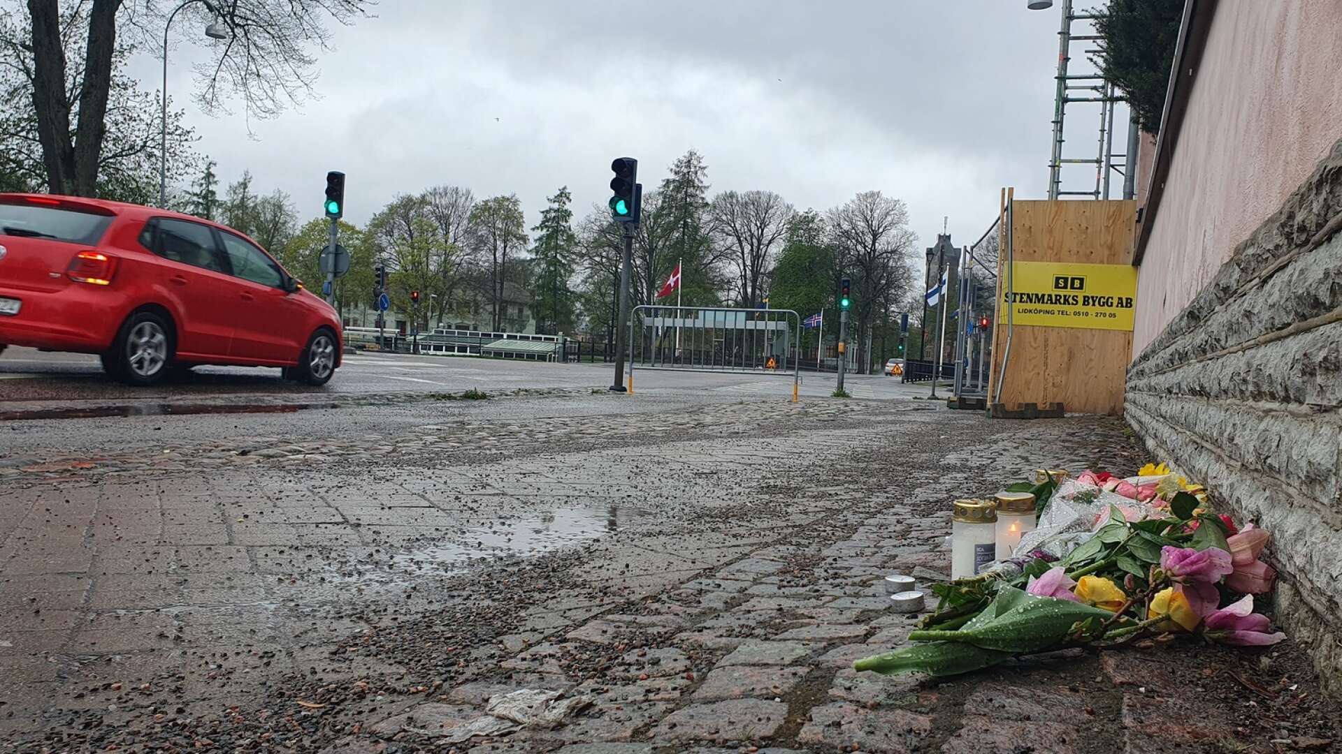 Ett par tända ljus och blommor syns vid olycksplatsen där en man i 50-årsåldern avled efter att ha blivit påkörd av en man i 20-årsåldern.
