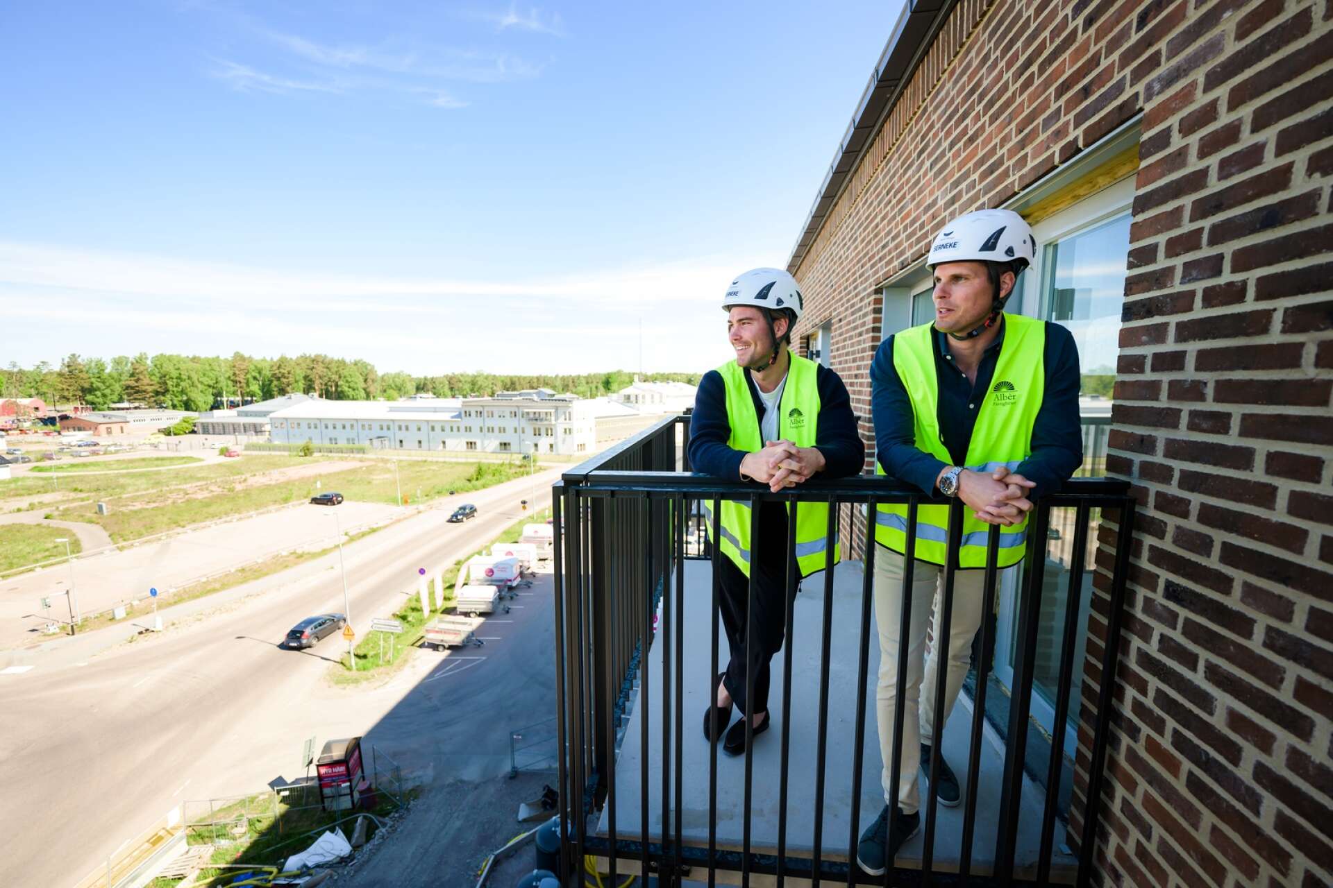 Med häktet i bakgrunden blickar Filip och David Eriksson ut över återvinningscentralen som är en del av utsikten på en del av balkongerna.