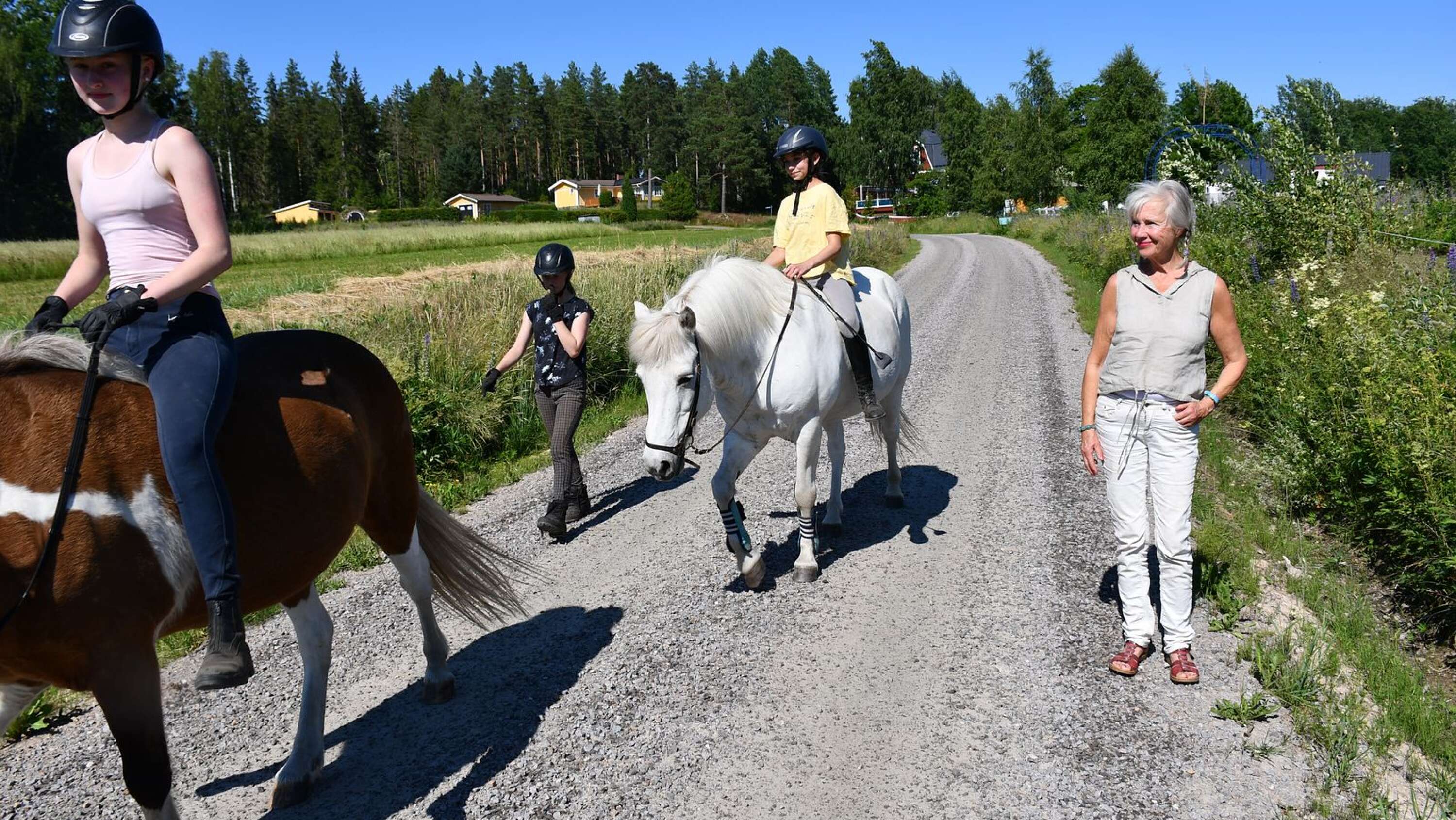 Karin Broos på grusvägen mellan bostadshuset och Alma Löv museum. Granntjejen och hennes kompisar får gärna ta en tur med hästarna.