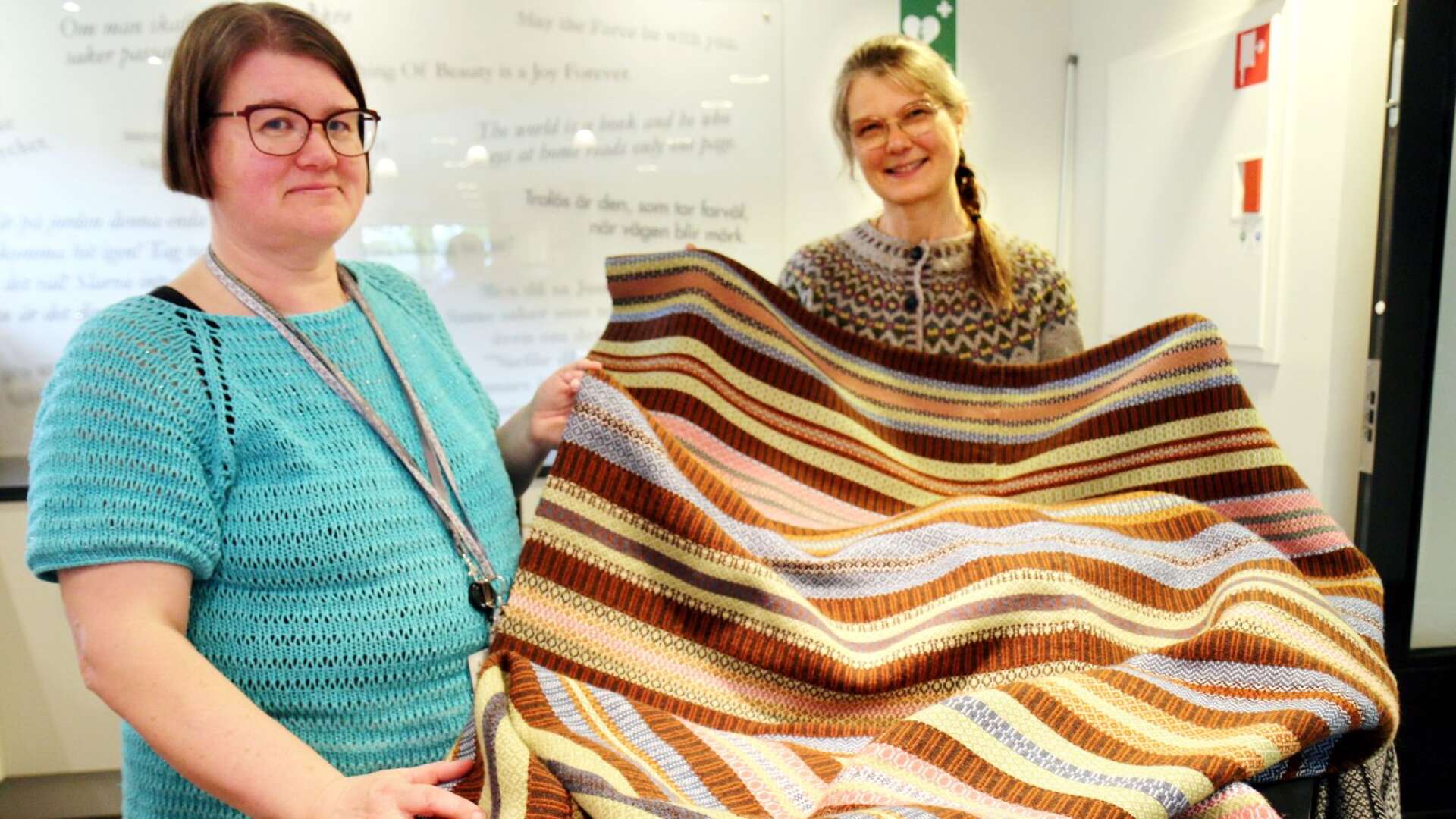 Hemslöjdskonsulent Kristina Brandt tillsammans med Hjobon Lotta Lundqvist som är en av ambassadörerna för projektet vävrosengång. Hon visar upp sin rekonstruktion av ett täcke som finns på Västergötlands museum.