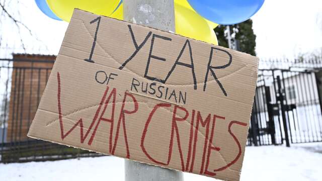 Plakat, och gula och blåa ballonger utanför Ryska ambassaden på årsdagen av Rysslands invasion av Ukraina den 24 februari 2023.