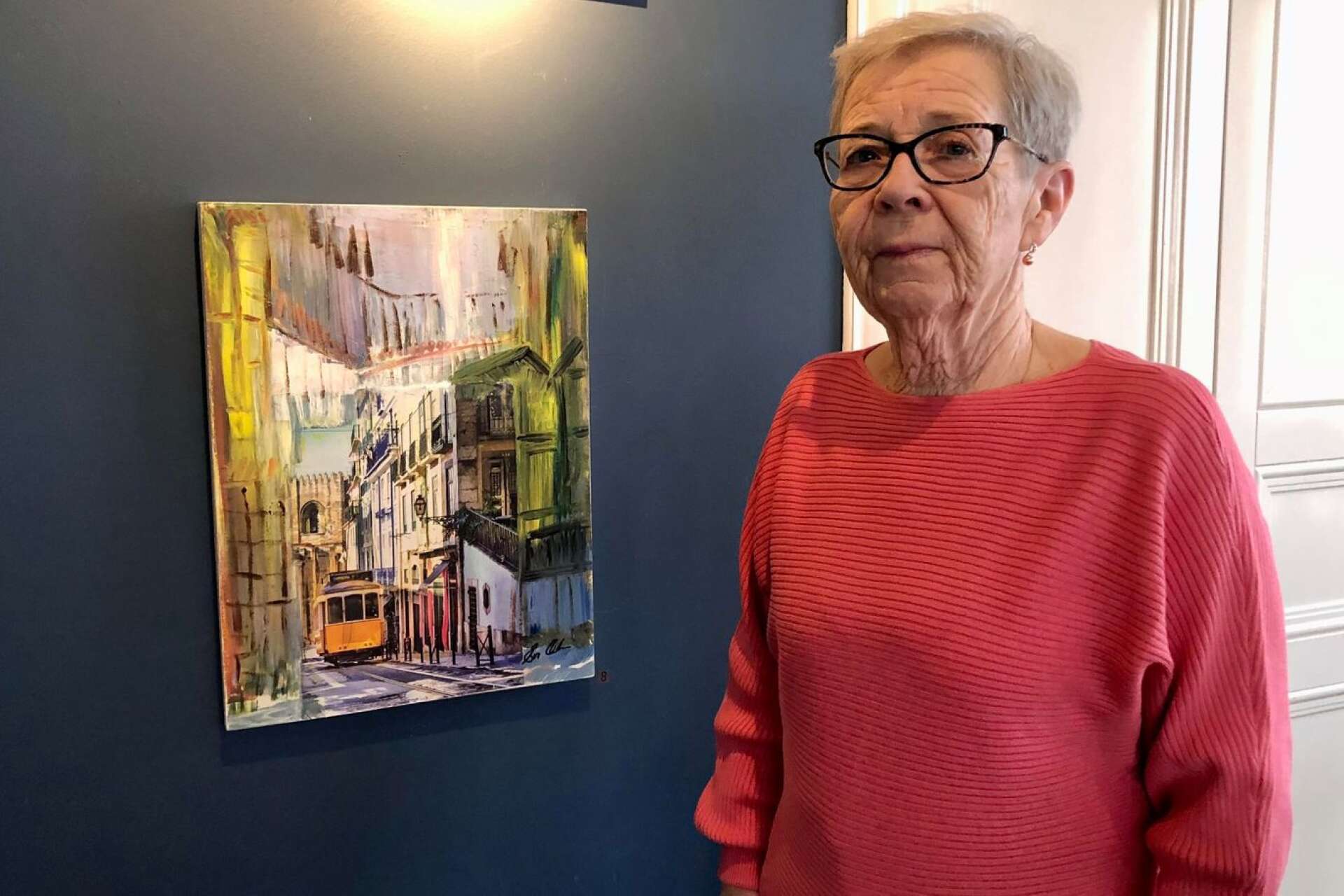 Eva Olsson med en av sina tavlor som finns med på utställningen på stadshotellet i Åmål.