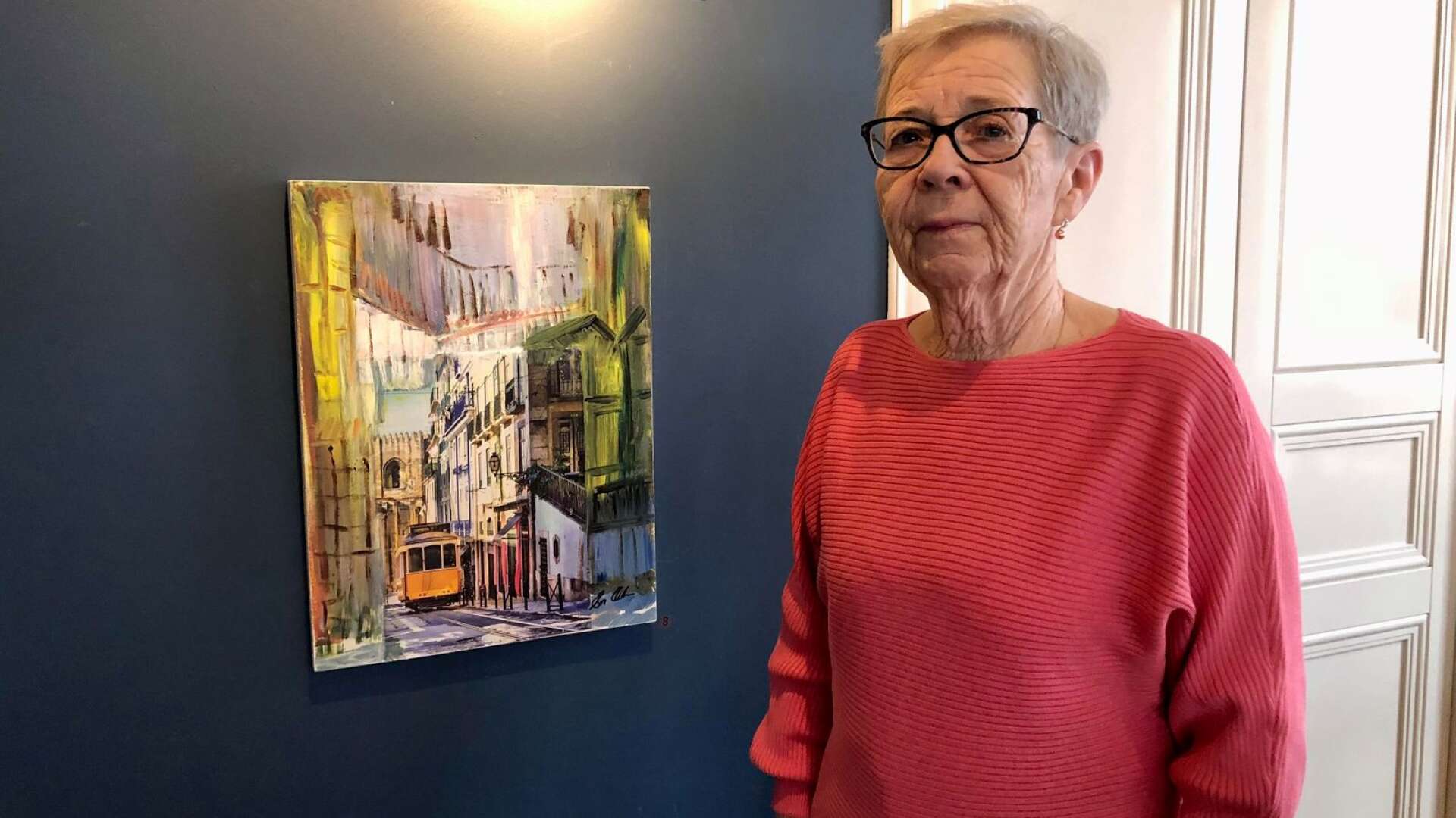 Eva Olsson med en av sina tavlor som finns med på utställningen på stadshotellet i Åmål.