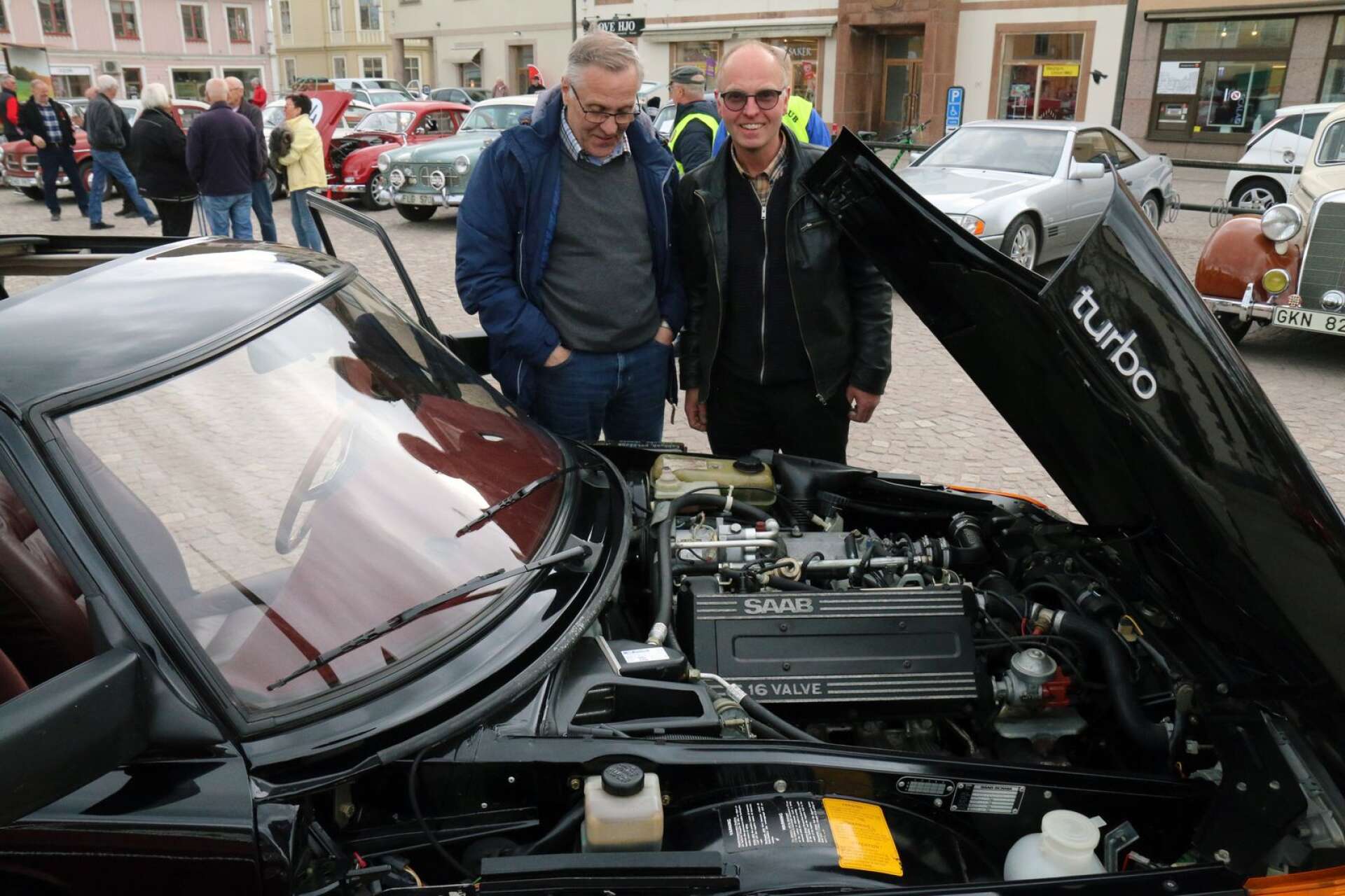 Lars Glad vid sin svarta blänkande Saab 900. Joakim Fredriksson, som själv kör Volvo Amazon, dök upp och sa &quot;tittut&quot;.