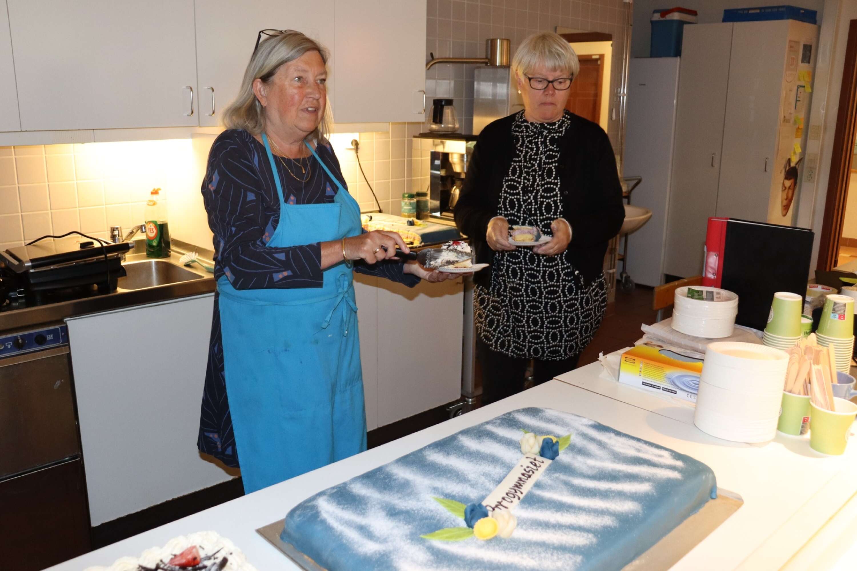 Ann-Katrin Andrews Johansson och Karin Nyvall skär upp tårta åt eleverna.