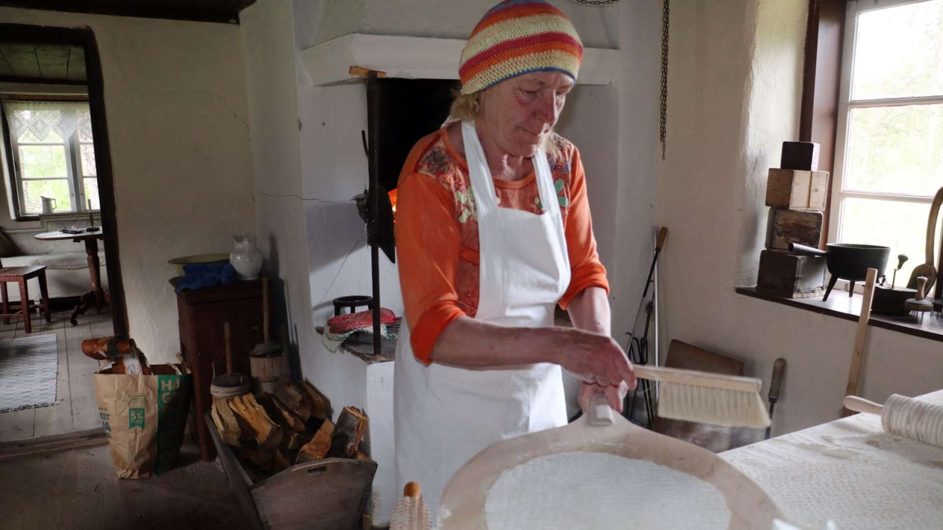 Lisbeth Abrahamsson borstar av det överflödiga målet från tunnbrödet för att brödet inte ska bli beskt.