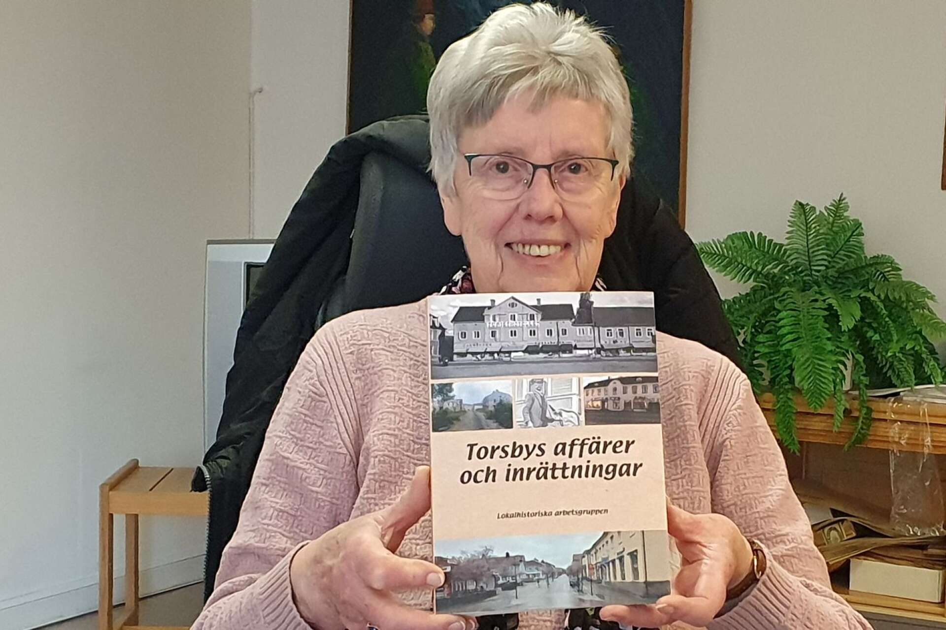 Berit Juhl med boken om Torsby centrum och som gjorts av henne och fem andra i Lokalhistoriska arbetsgruppen.