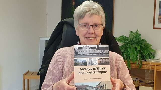 Berit Juhl med boken om Torsby centrum och som gjorts av henne och fem andra i Lokalhistoriska arbetsgruppen.
