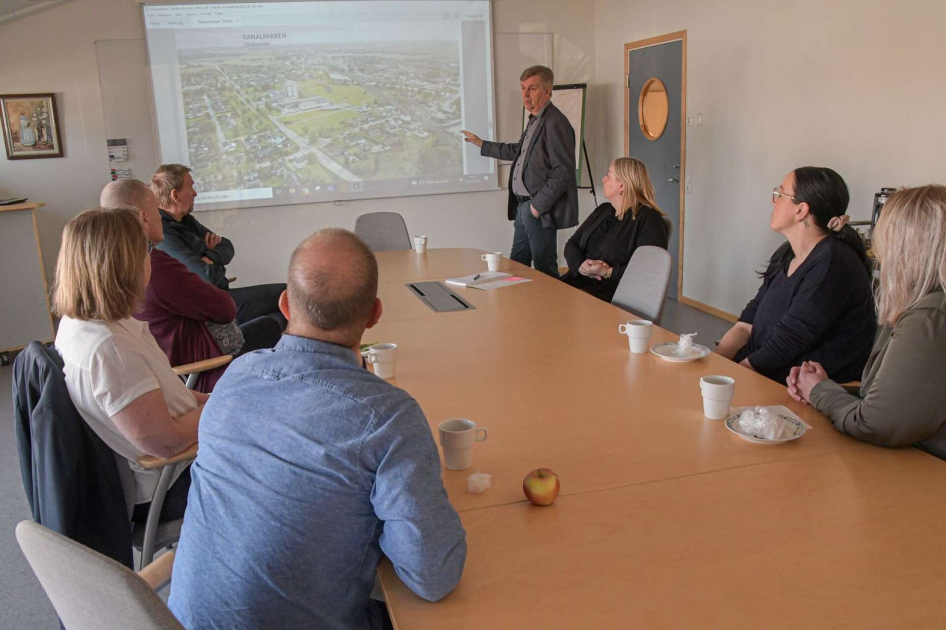 Samling i en konferenslokal på Björkängen, före besöket på bygget. Bengt Sjöberg pekar ut vad som är vad på Törebodakartan för gästerna.