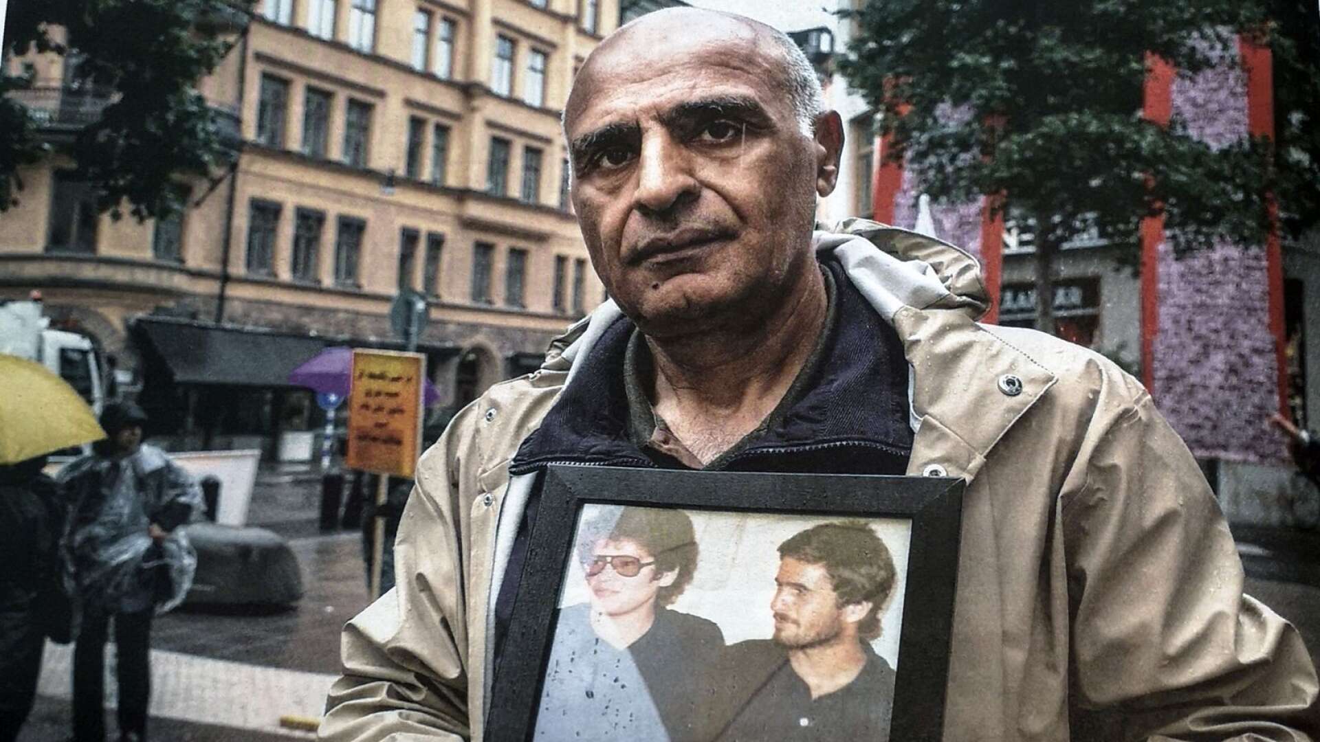 Morteza Sadeghi håller upp en bild på hans vänner som avrättades under sommaren 1988. Till vänster Amir Sandoghchesaz, 26 år, och till höger Faraj Nankeli 30 år.