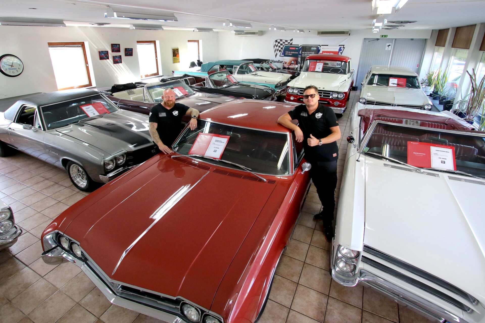 Funny Garage ägare Kristian Kronvall (till höger) och säljare Johan Törnqvist kan konstatera att det trångt i de gamla lokalerna på Mariestadsvägen. En röd Oldsmobile Starfire 1966 är en av salubilarna.
