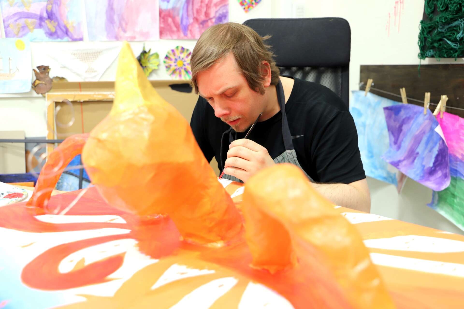 Dennis Hjalmarsson jobbar koncentrerat med detaljerna på sin målning, där en Fenix-figur dyker upp i 3D.