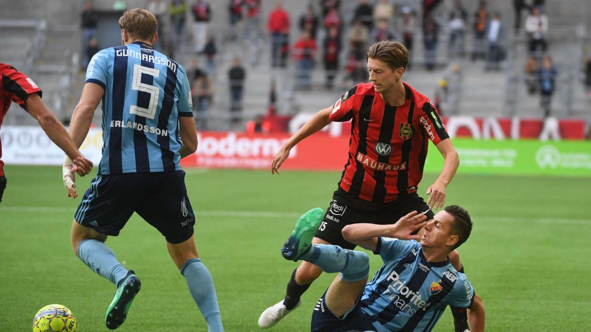 Djurgårdens Niklas Gunnarsson och Haris Radetinac mot Brommapojkarnas Johan Falkmar under en fotbollsmatch i allsvenskan.