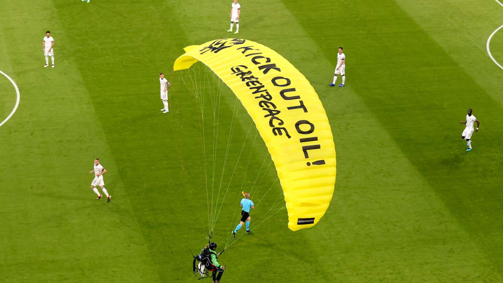 En aktivist från Greenpeace kraschlandade med fallskärm under EM-matchen i fotboll mellan Tyskland och Frankrike.