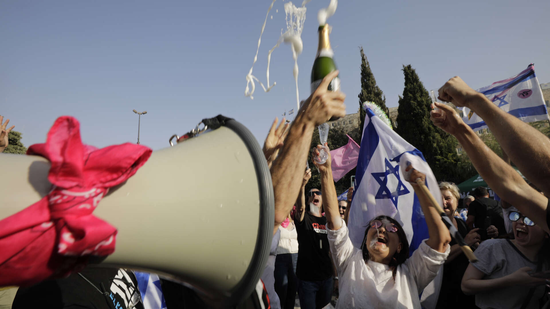 Folk firar efter beskedet att Israels parlament röstat igenom den nya regeringen.