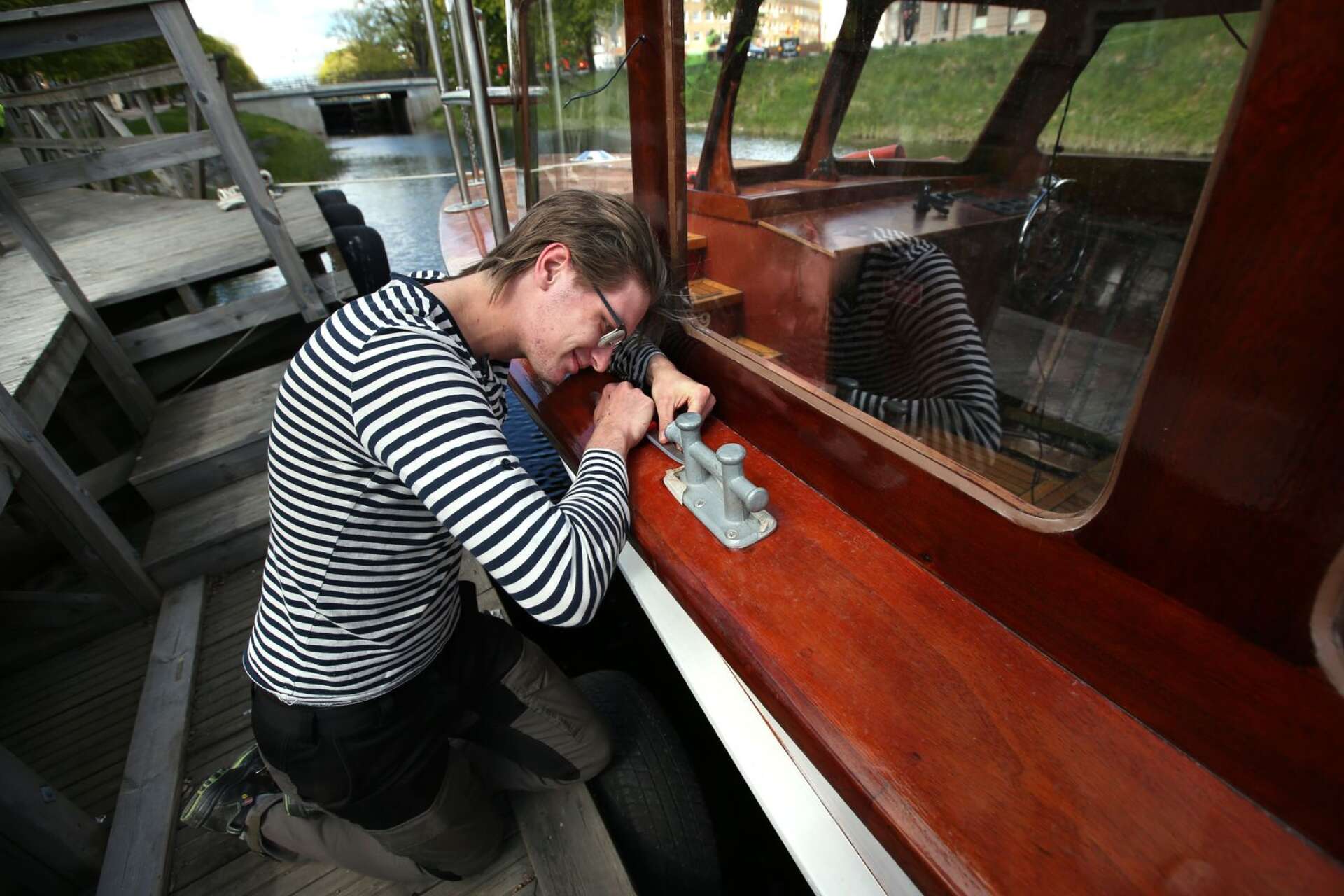 Pontus Nordman tar bort de sista resterna av maskeringstejp. I vinter har han gjort sitt examensarbete på trätekniska programmet med att renovera båten Per Persa.