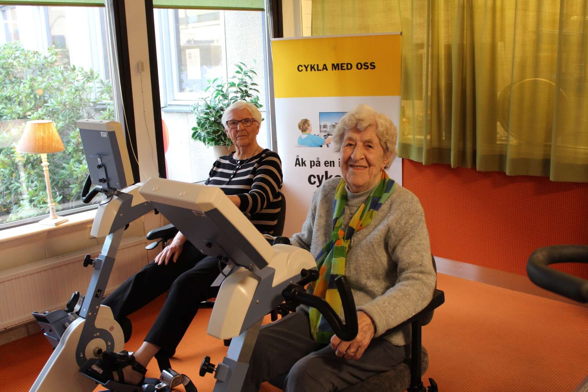 Gunnel och Maj-Lis gillar att röra på sig. På en interaktiv cykeltur kan de via en skärm cykla på välkända gator i Karlstad. ”Vi har också cyklat i Arvika och Paris”, berättar de. Att de båda fyller 94 år senare i år är svårt att tro.