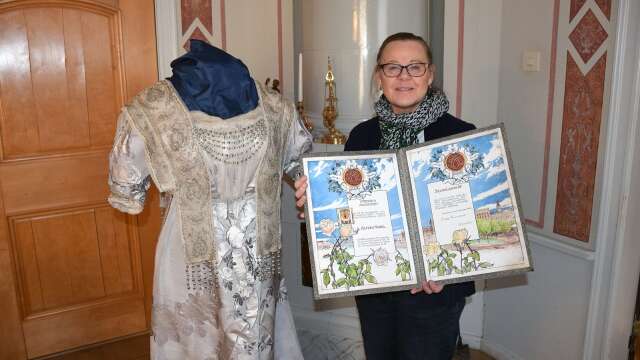 Mårbacka minnesgårds chefsguide Lena Larsson visar Selma Lagerlöfs prisdiplom och hennes berömda Nobelklänning.