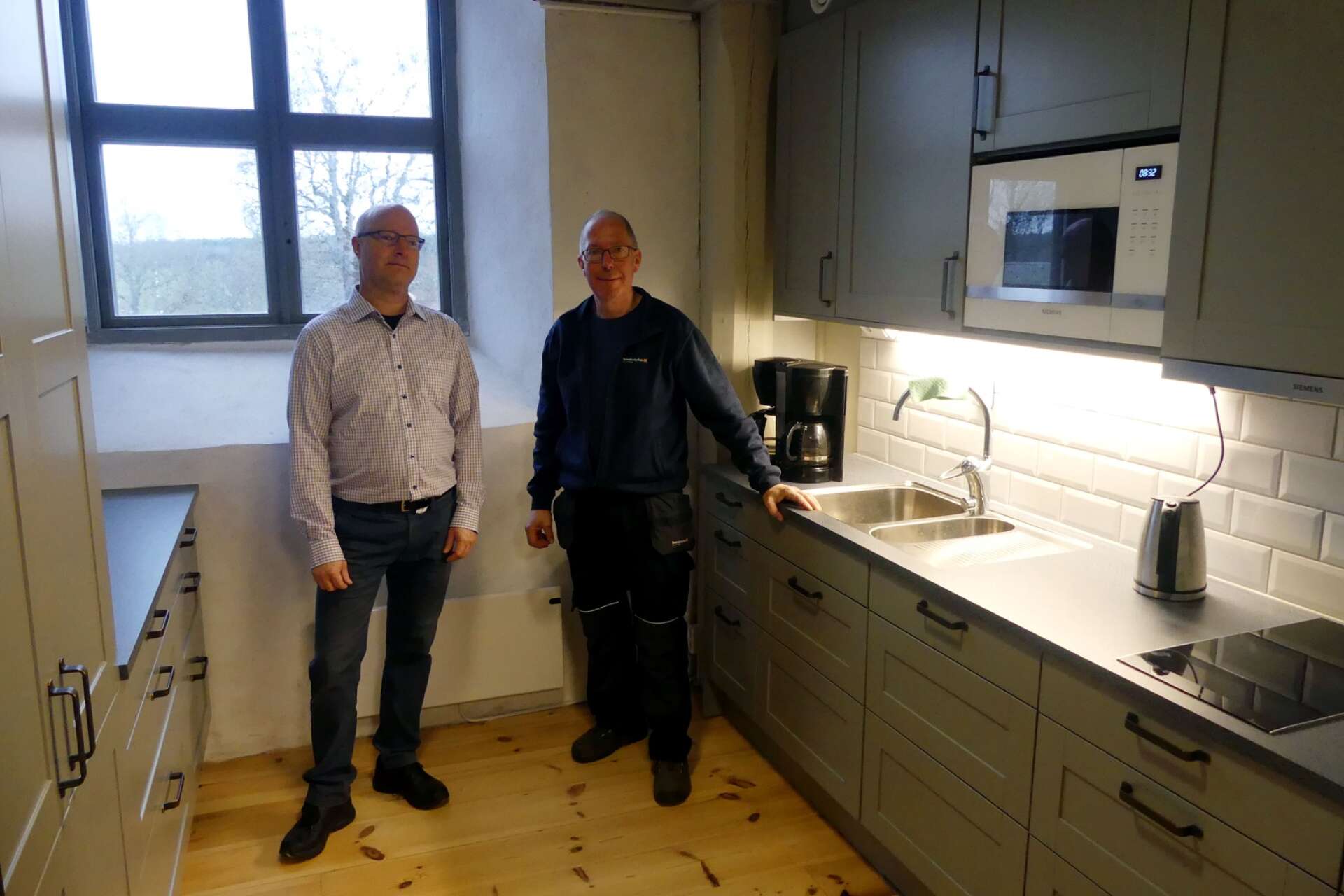 Stefan Sköld, Bro församlingsråd, och Gunnar Bäckström, vaktmästare Bro kyrka, visar upp det nya köket.