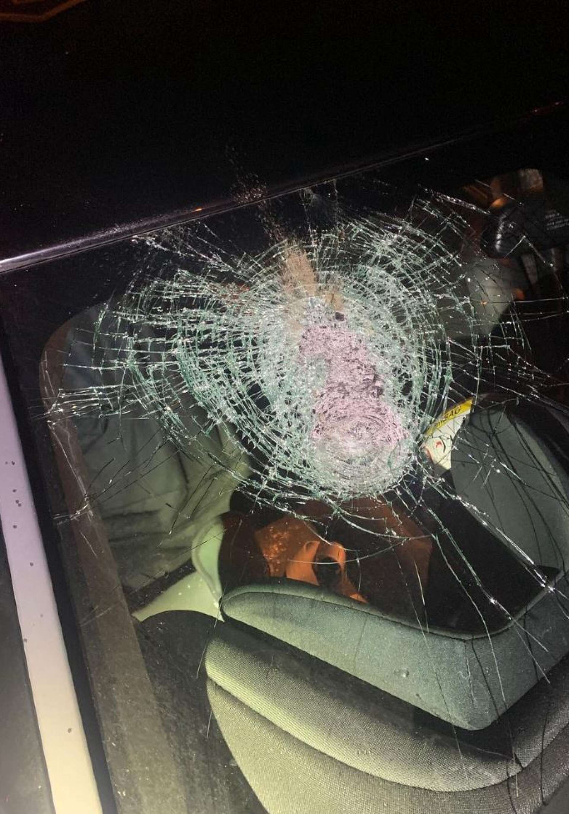 En sten träffade vindrutan – alldeles ovanför där ett barn satt i sin bilbarnsstol. Bild från polisens instagram.