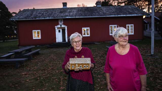 Gun Ågren och Lena Andersson visar upp pepparkakshuset som är identiskt med Hammarös hembygdsgård.
