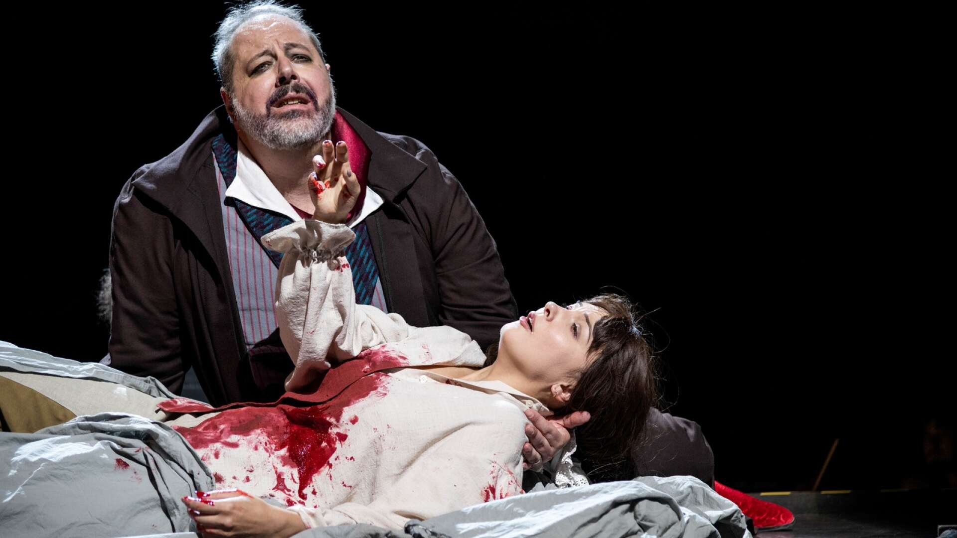 Det väjs inte för blod och mörker när Opera på Skäret sätter upp Verdis Rigoletto. Här gör Stefano Meo titelrollen och Alina Tkachuk Rigolettos dotter Gilda.