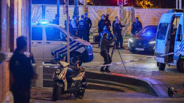 Belgisk polis på platsen i Bryssel där två svenska fotbollssupportrar sköts ihjäl under måndagskvällen.