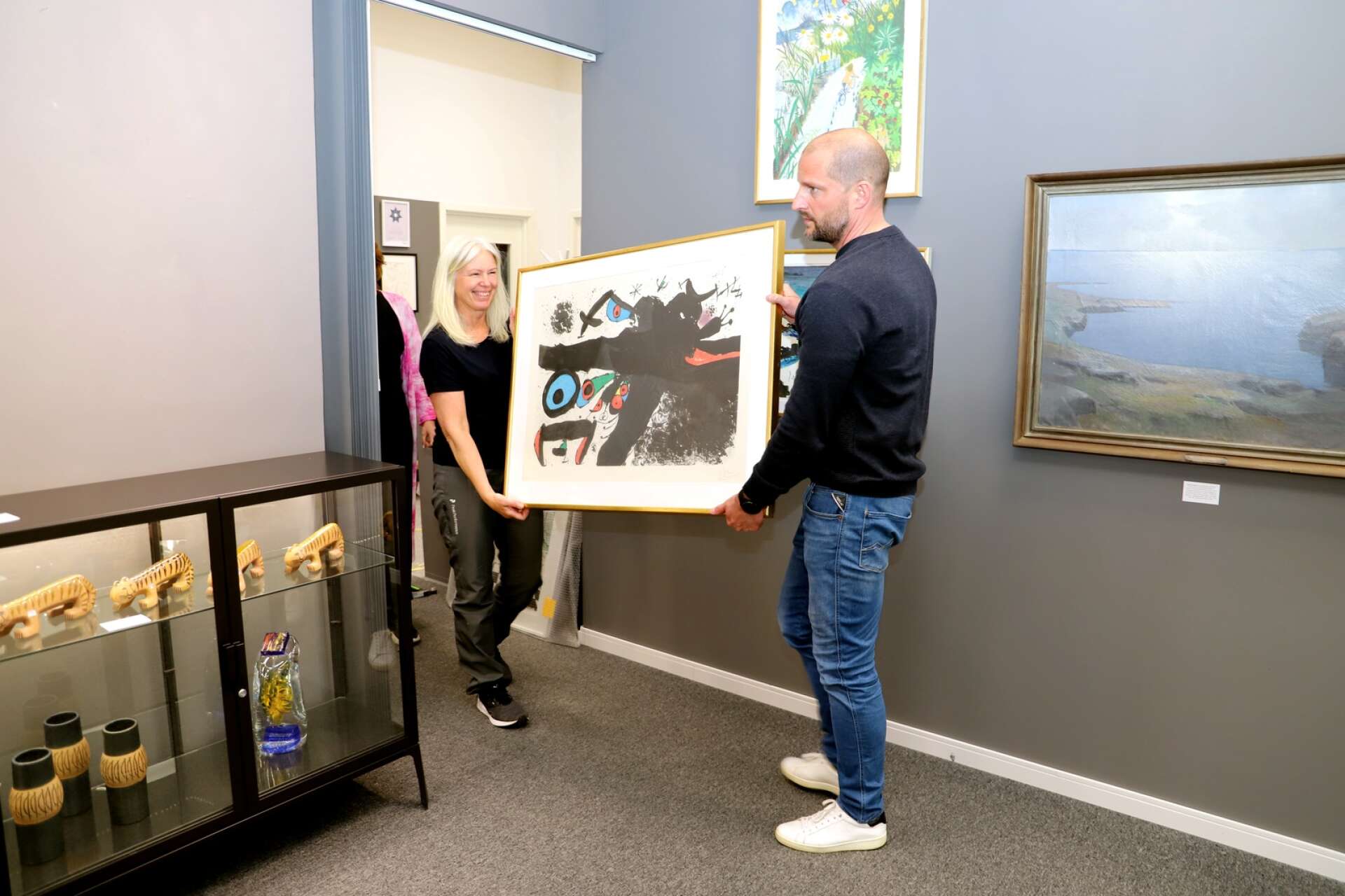 Ylva Storm och Mattias Frykholm bär in Miró-verket, som visas i utställningen Konsten i Konsum, som pågår på Hammarö art gallery 21-23 april.