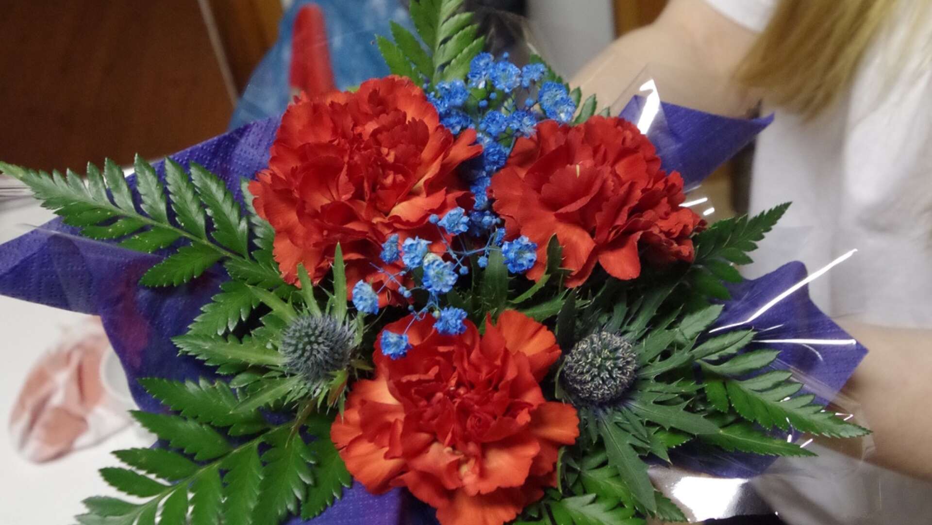 Borden var vackert dekorerade med blomarrangemang i Kila IF:s färger, rött och blått. Linn Öberg visar upp en &quot;Kilablomma&quot;