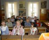 Skolklass som besöker ett riktigt gammalt klassrum. 