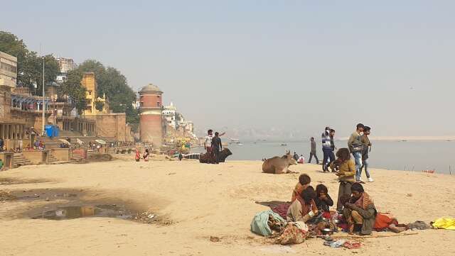 På kvällarna sitter hela familjer och trängs runt en liten eld som de tänder på gatan för att få värme och kanske kunna laga sig ett mål mat. Här har en familj slagit sig ner på den heliga floden Ganges strand.