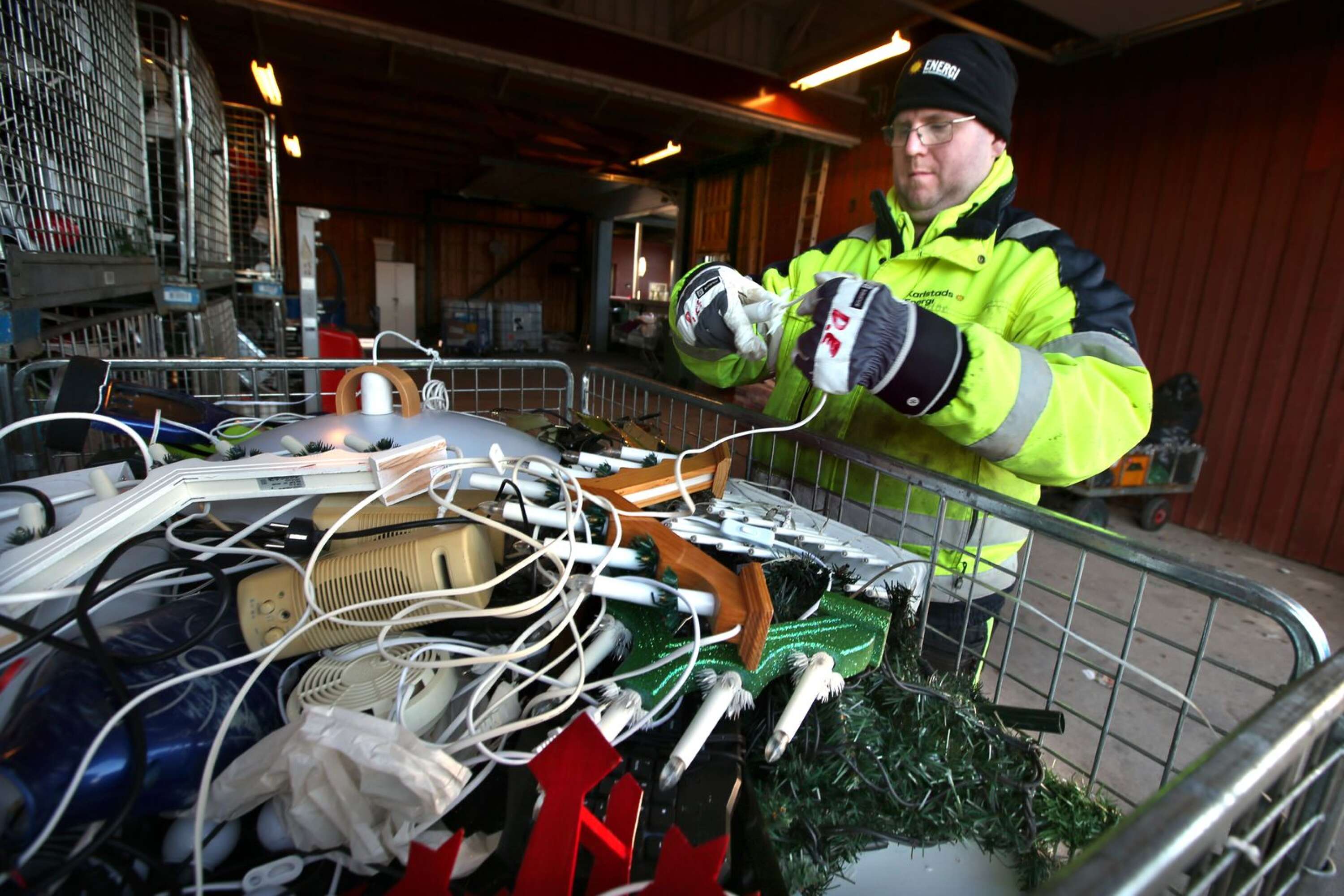 Daniel Eriksson skruvar bort en glödlampa som någon låtit sitta kvar i den slängda juldekorationen.
