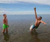 Maxx Persson och Albin Djup kastar boll i vattnet.