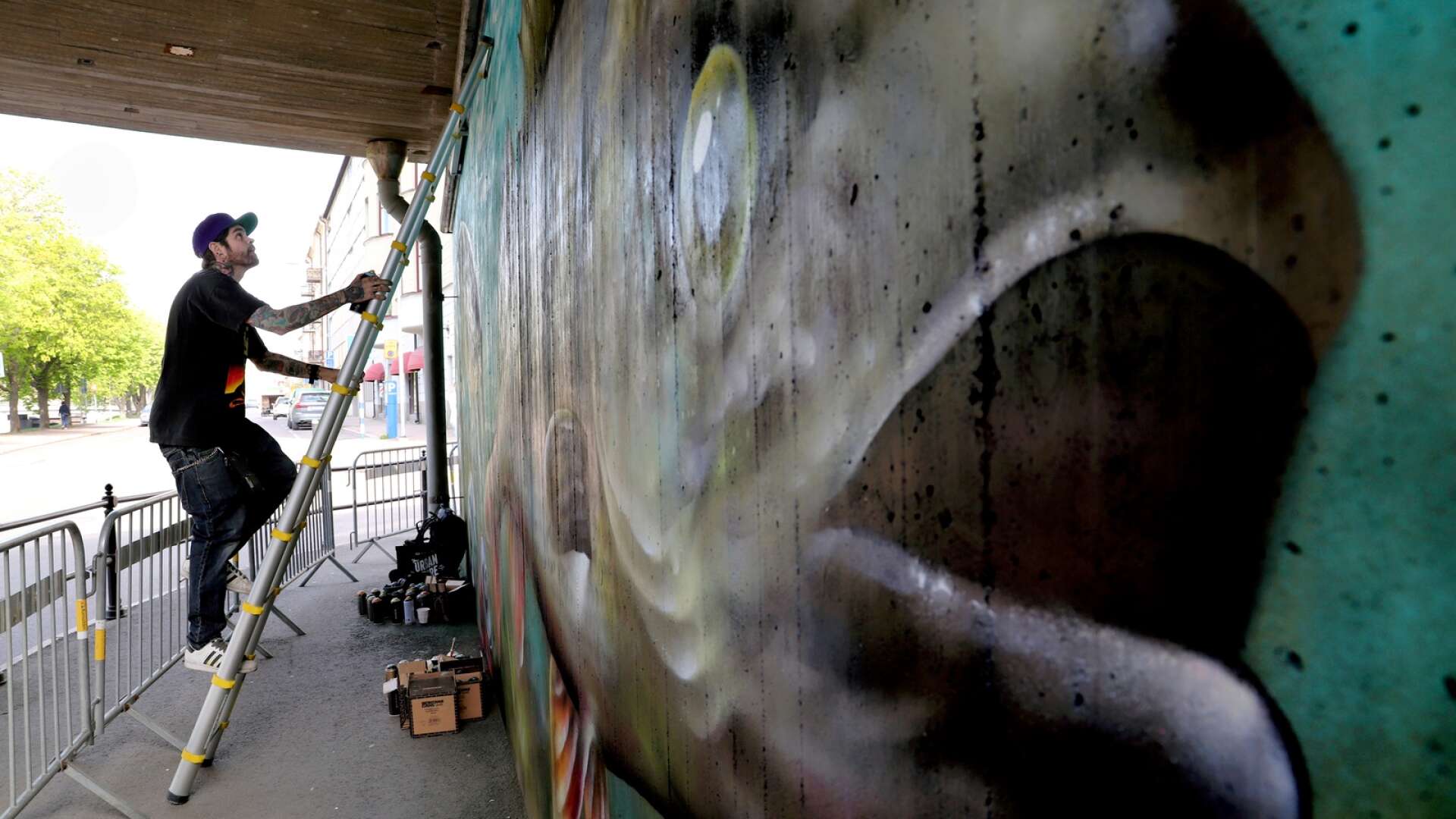 Konstnären Sagie, alias Christofer Siwertz-Svedjeby, har under veckan arbetat med en stor väggmålning under gångbron vid kanalen nedanför Nöjesfabriken. Motivet är tänkt att få folk att stanna upp och tänka till.