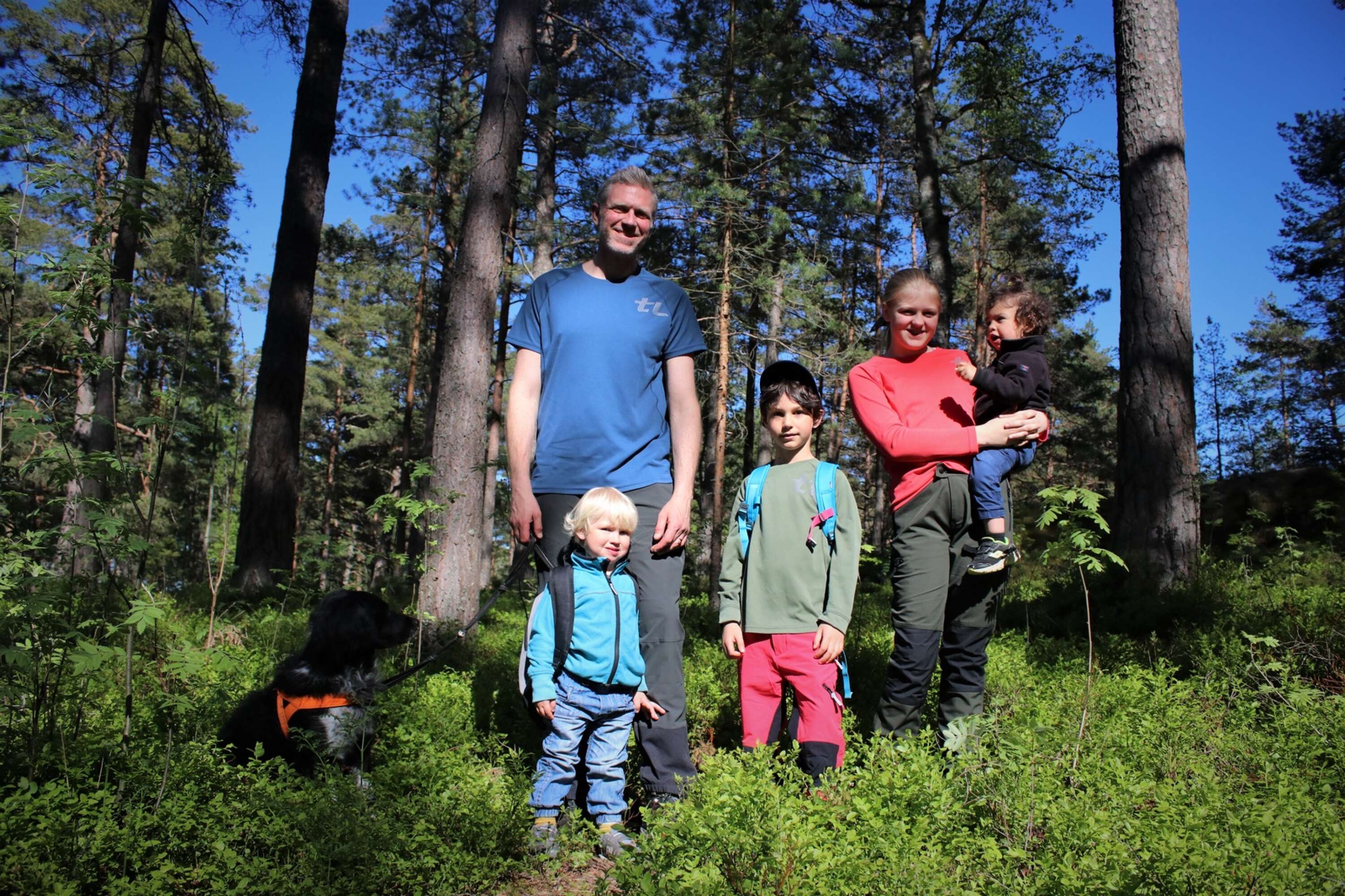 Andreas Junzell utforskar Örnässkogen tillsammans med barnen John, Salim, Agnes, Manal och hunden Tesla.