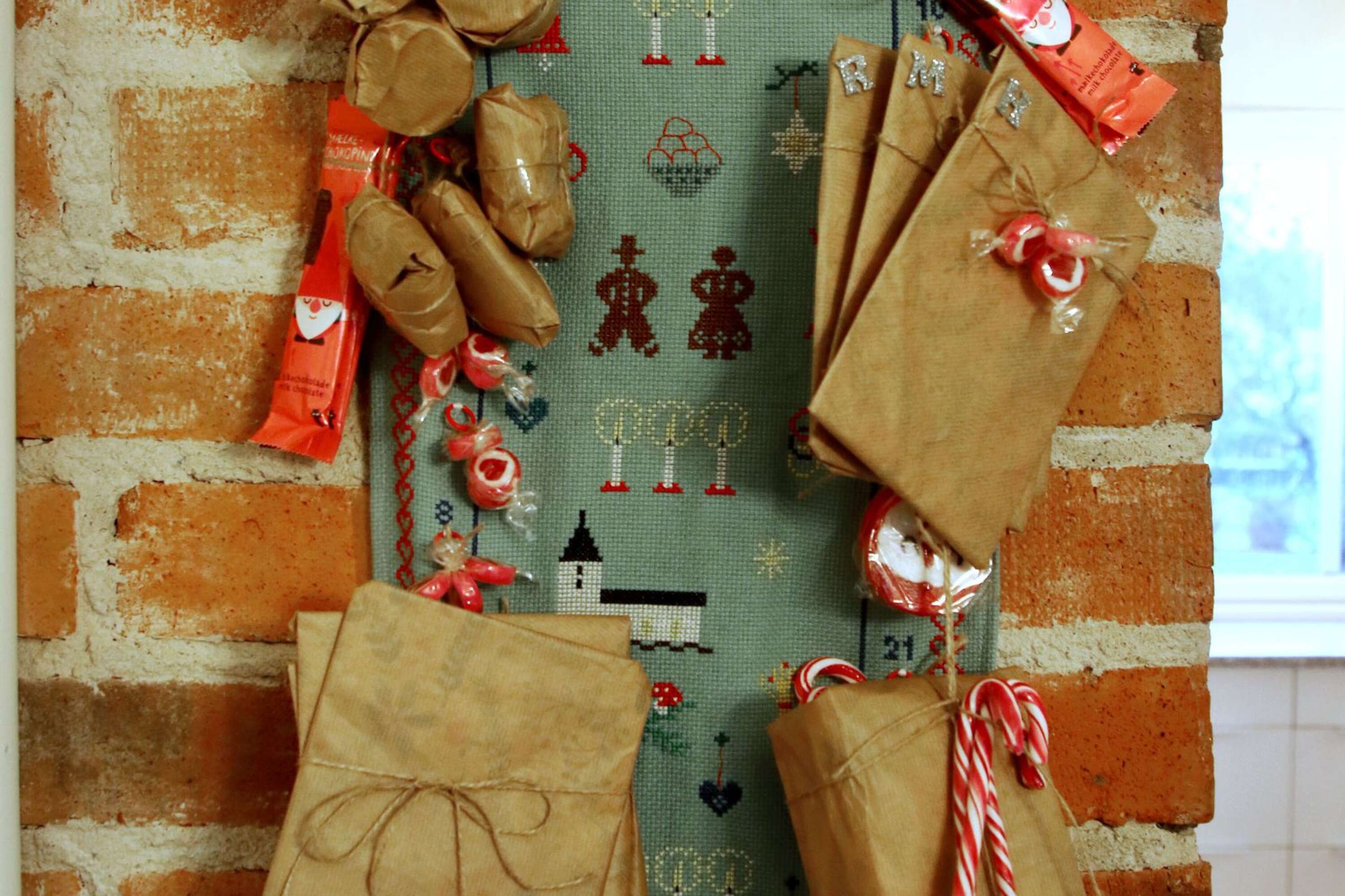 Årets paketkalender hos familjen Eriksson är en bonad som hennes farmor handbroderat. Små paket varvas med klubbor och polkagrisstänger. 