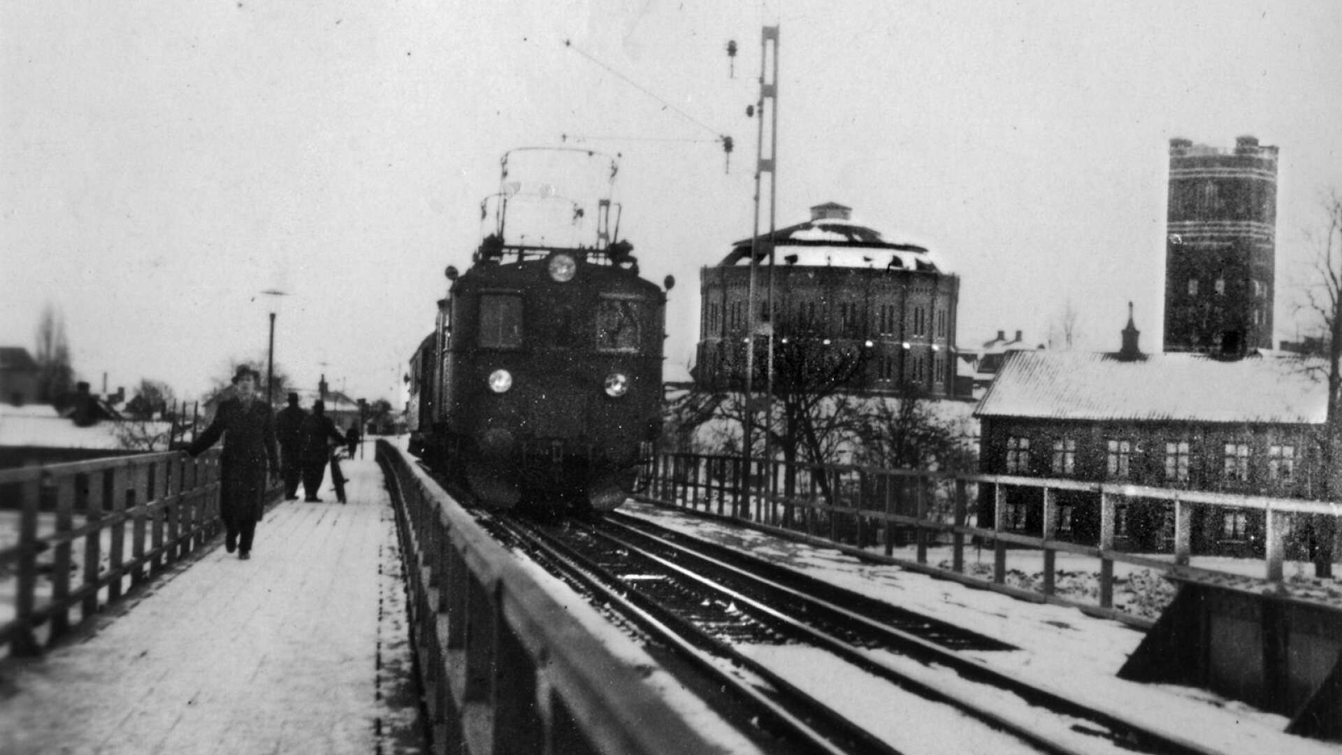 Järnvägsbron under 1940-talet med gasklockan och vattentornet på Kvarnberget i bakgrunden. En person har beskrivit det för hembygdsföreningen hur det var att möta tåget: ”Att gå över järnvägsbron när tåget kom var lagomt roligt och kusligt och det kändes i hela kroppen.”